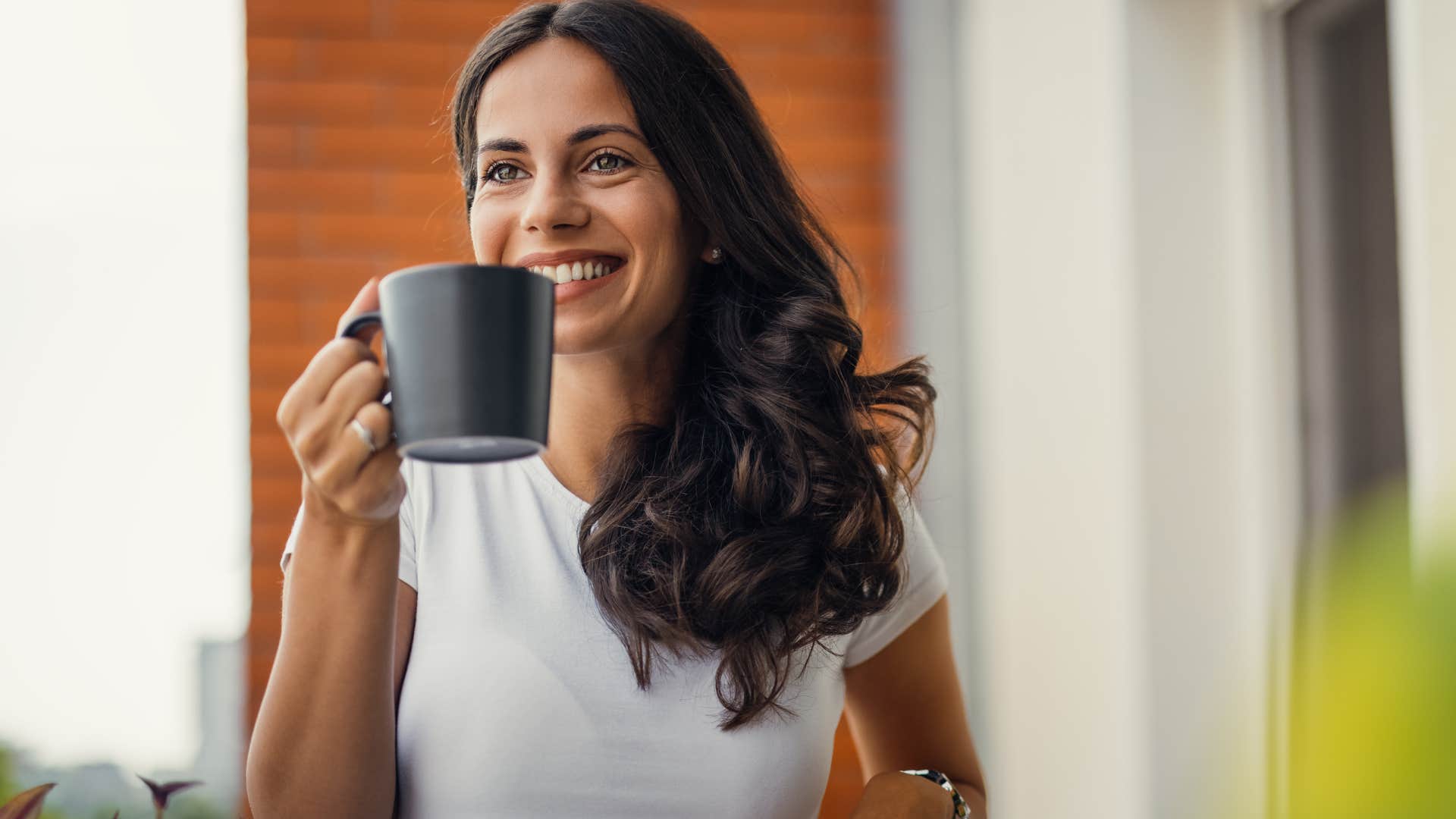 Woman smiling with drinking coffee and tea at home.