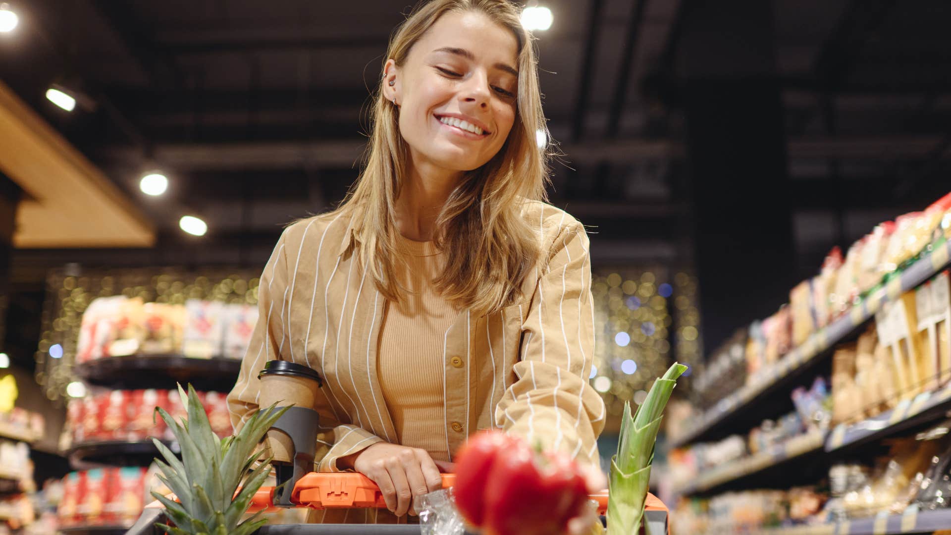 Woman smiling and shopping for seasonal produce at the store.
