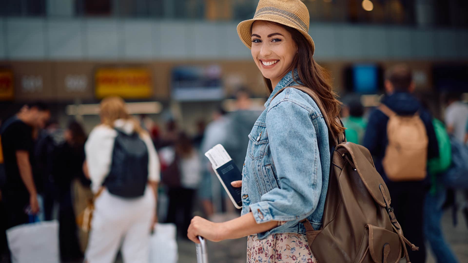 happy frugal woman at the airport after planning a trip