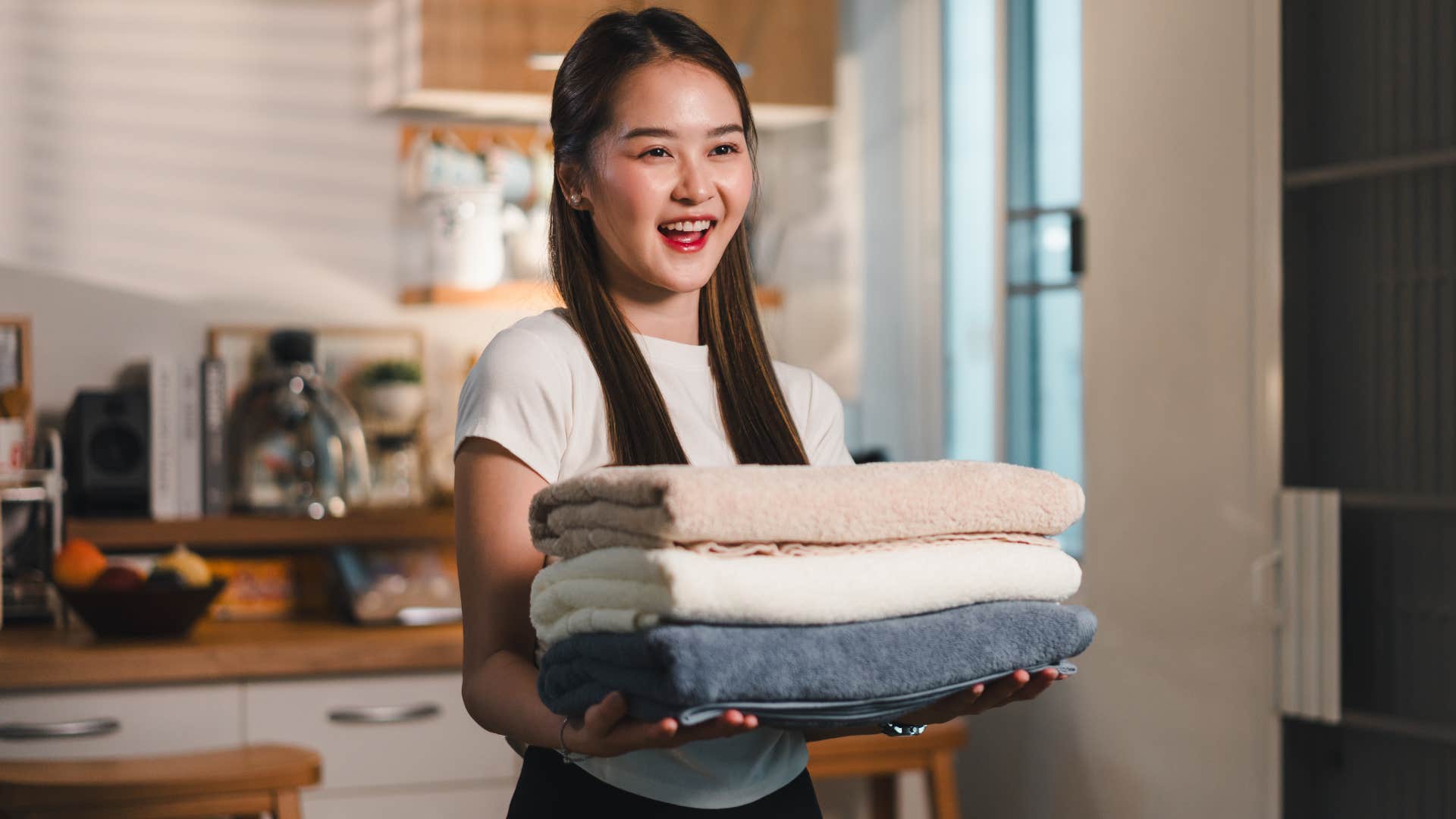 rich woman holding stack of decorative towels