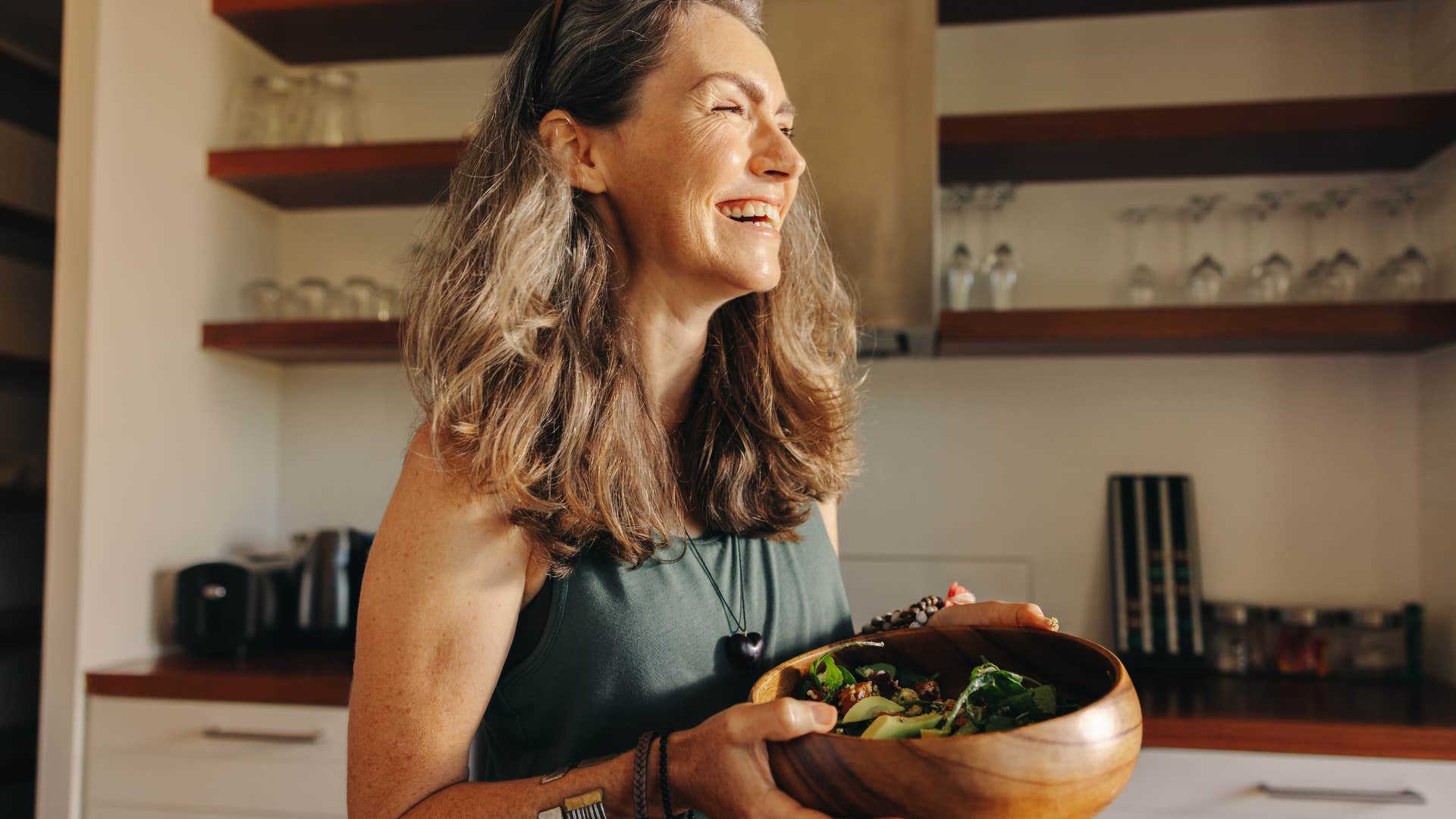 woman with name-brand items in home smiling in the kitchen