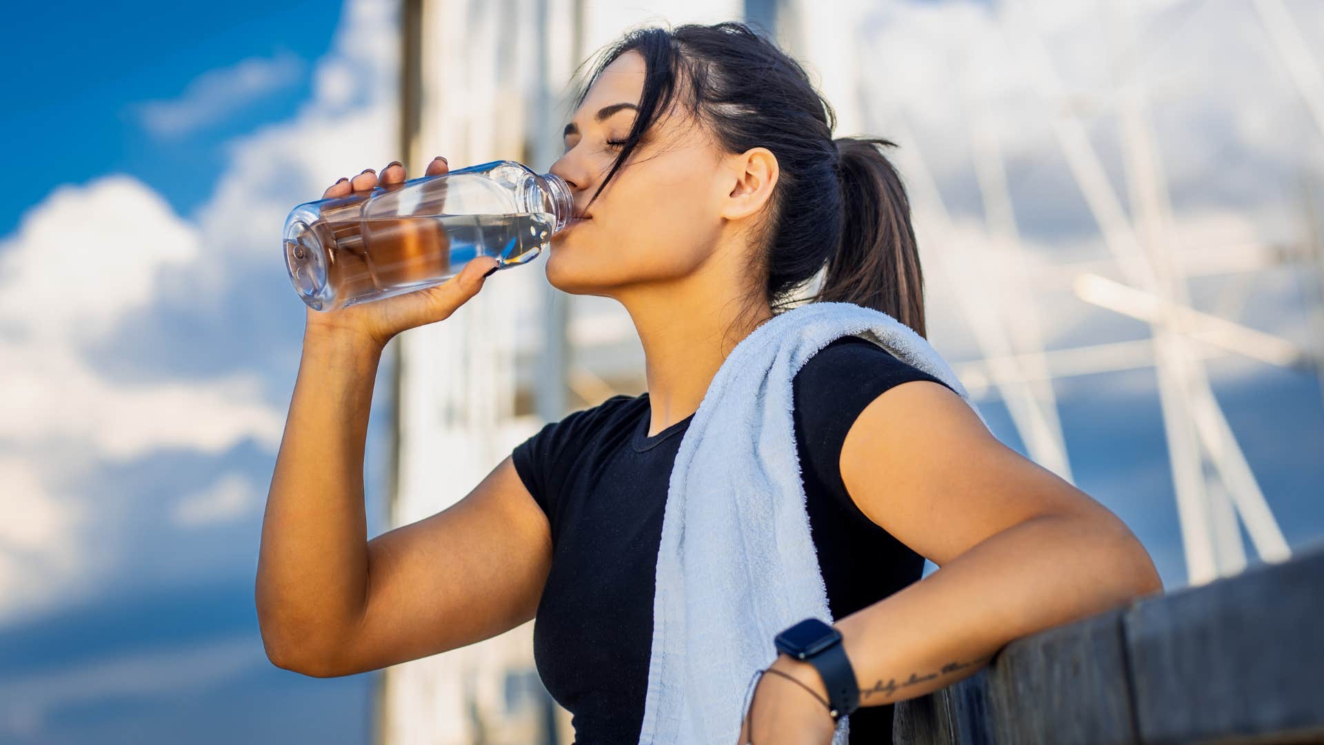woman in black shirt drinking bottled water outside