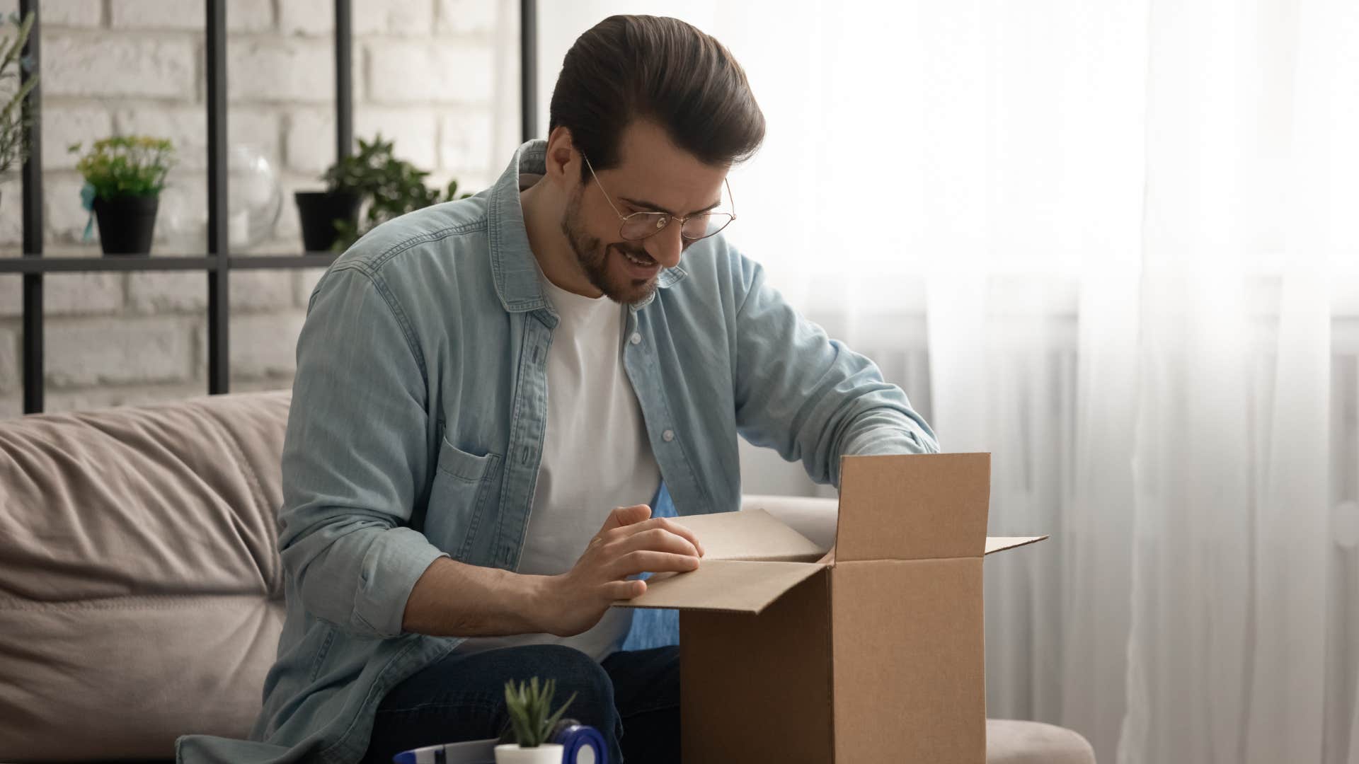 man unpacking cardboard box to save for later