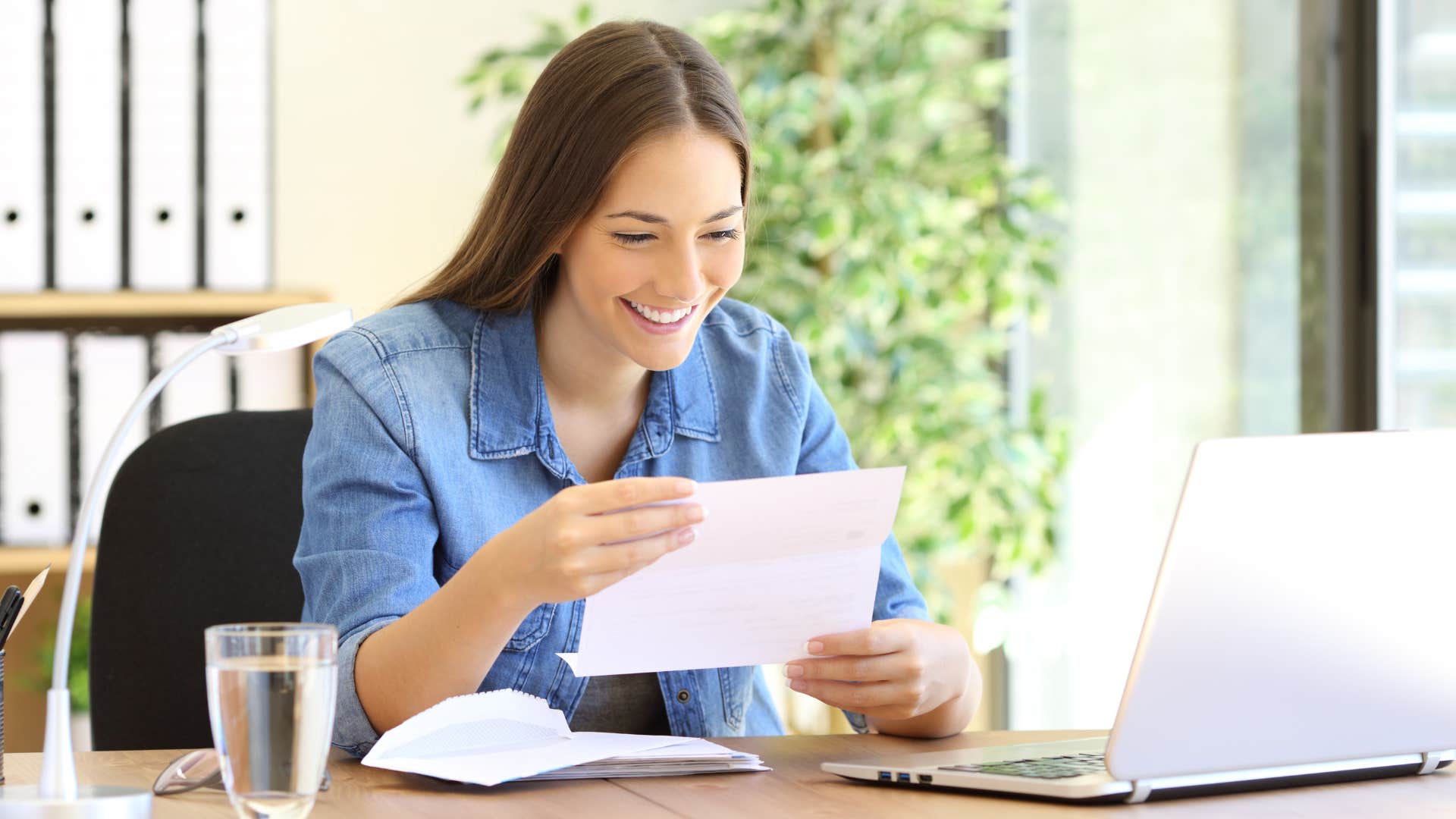 woman opening letter and saving envelope