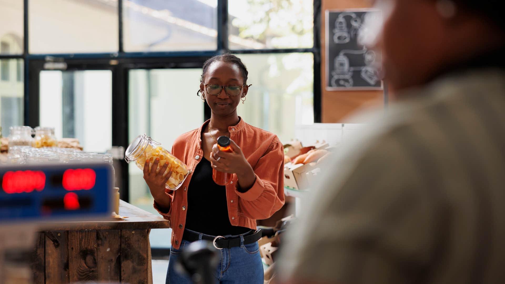 frugal woman holding mason jar at store