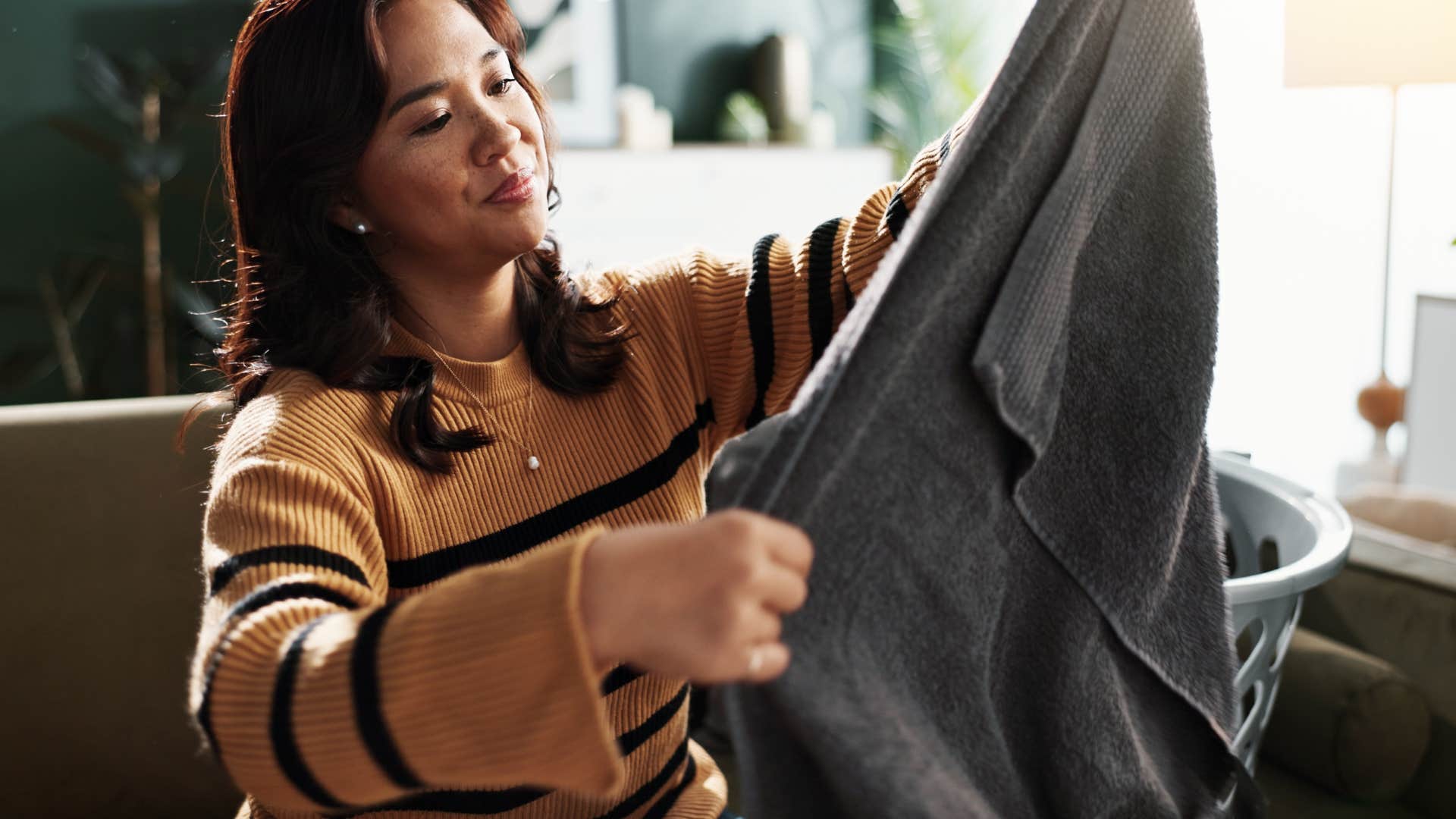 woman folding decorative towels for bathroom