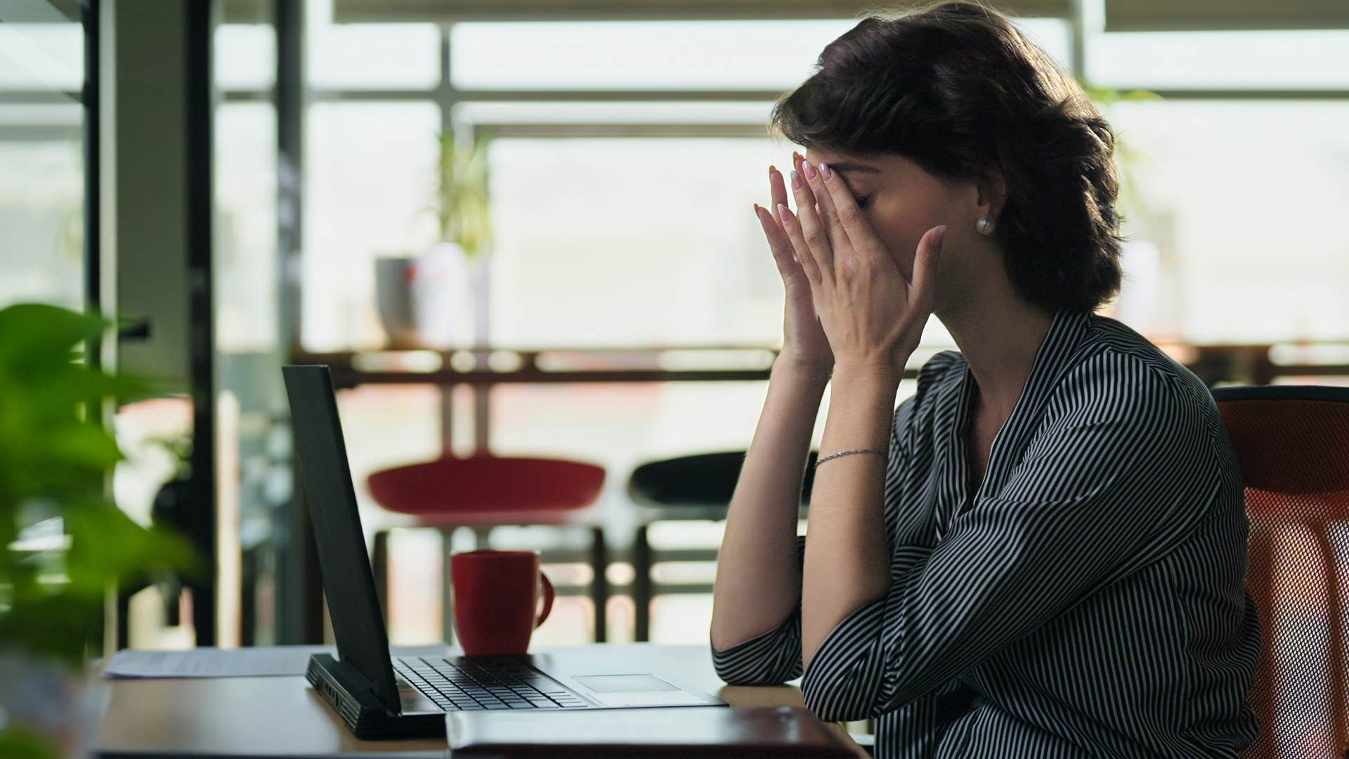 woman with head in hands sitting down and thinking i feel a bit overwhelmed right now can we take a pause