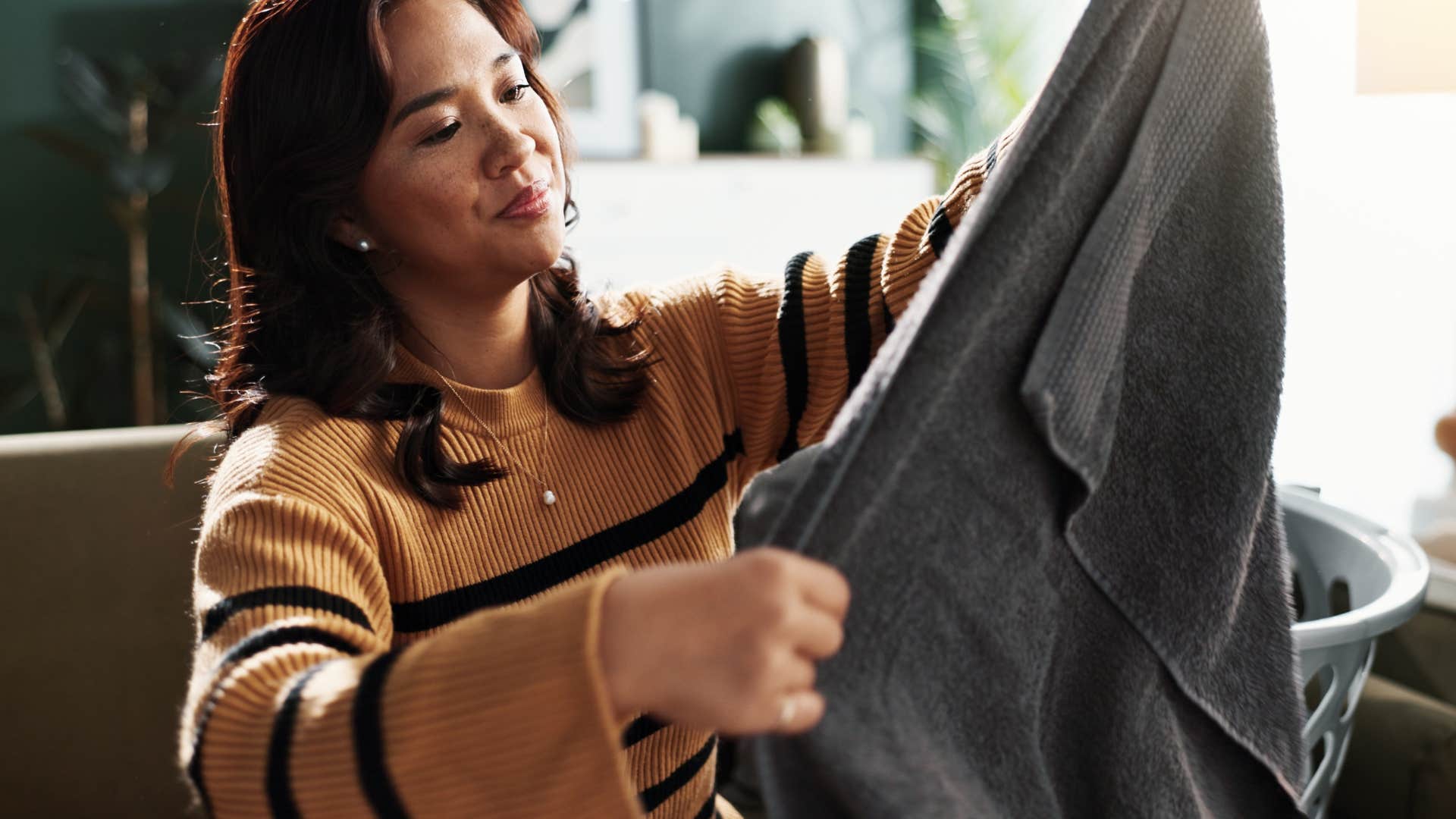 Woman folding decorative towels at home that shouldn't be used