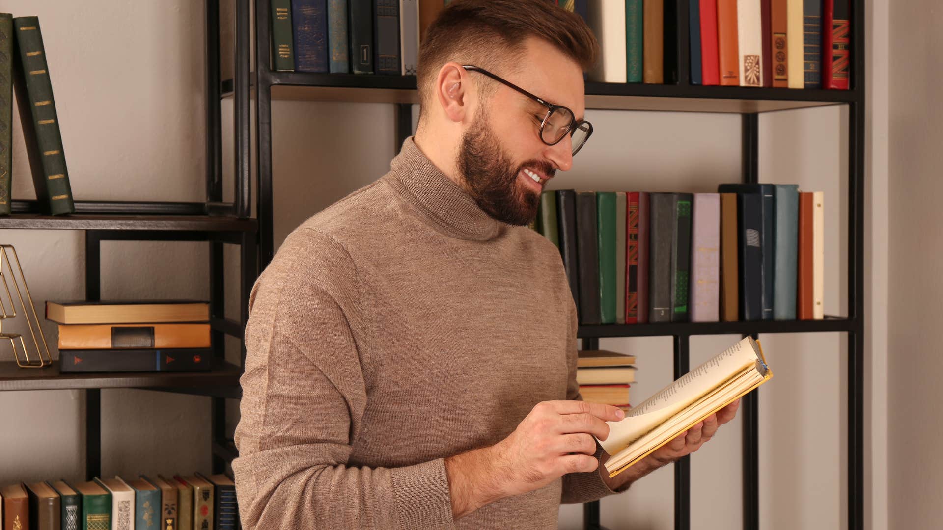 Man reading encyclopedias at home.