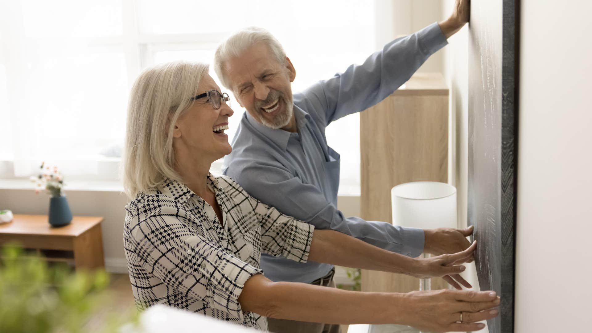Couple smiling at 'Live, Laugh, Love' art and signs with generic quotes