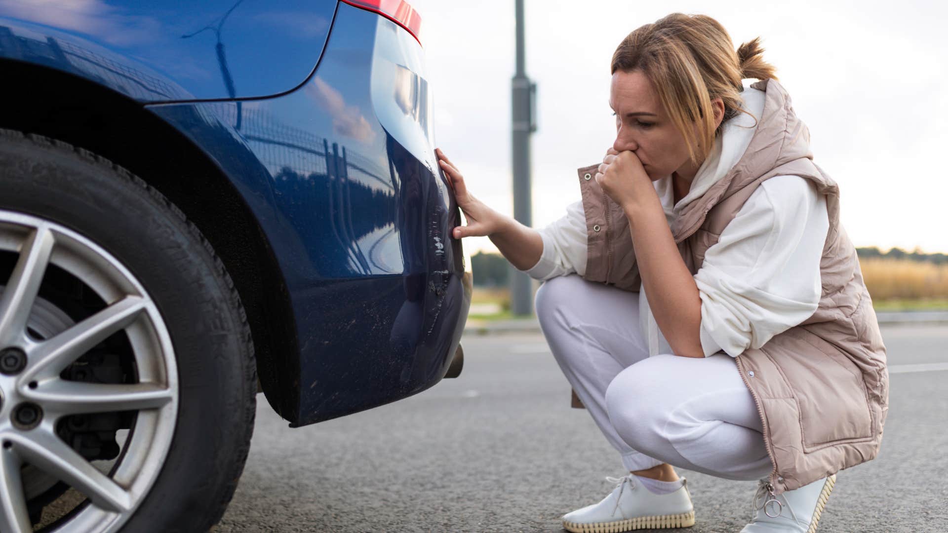 boomer woman looking at the bumper stickers on her car trunk