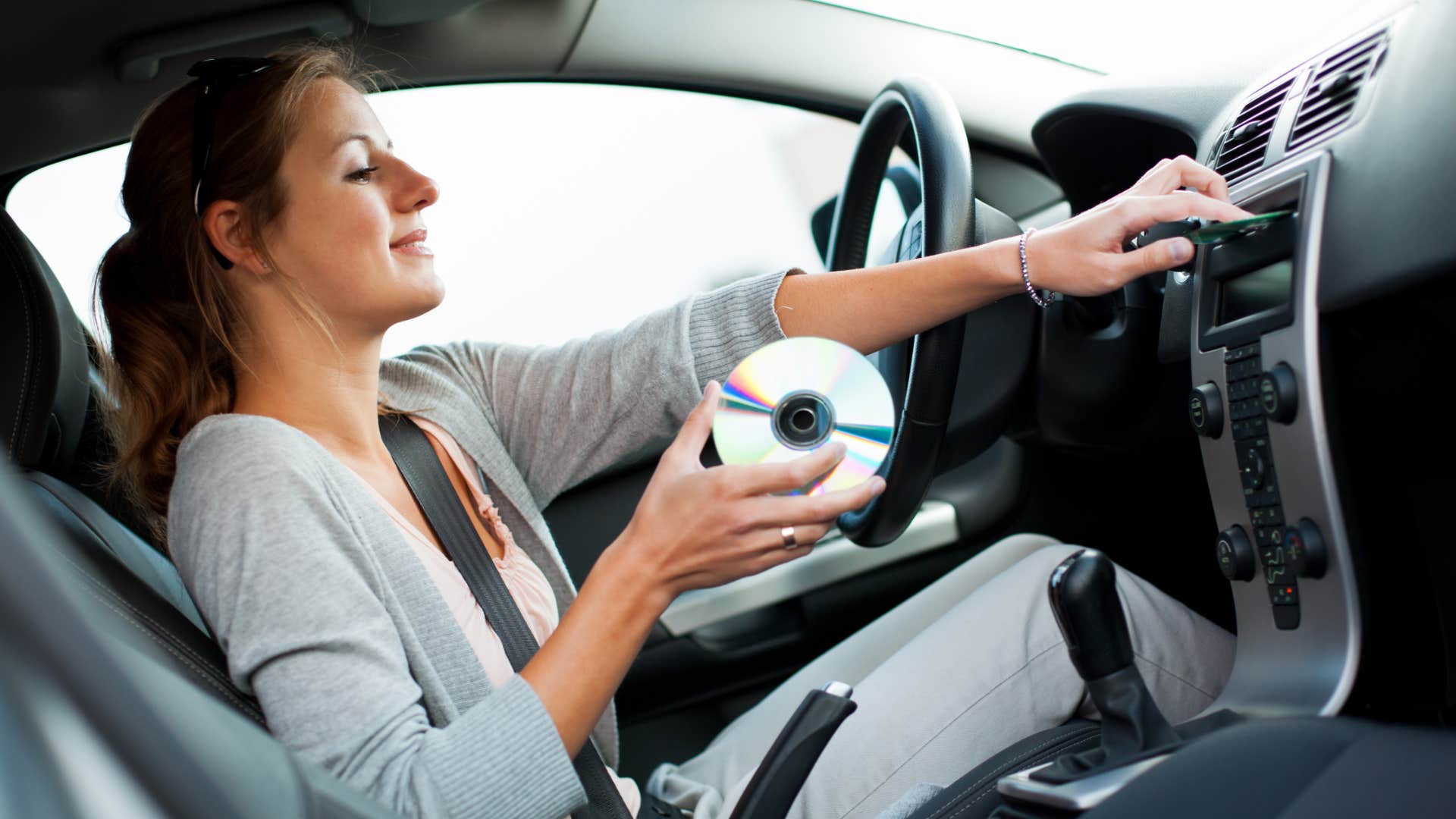 gen z woman holding cd in boomers car 