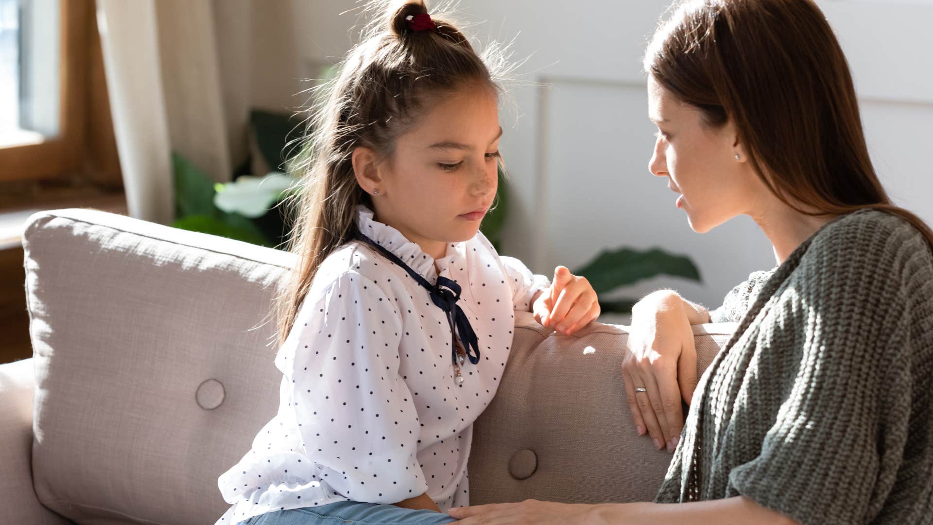 woman talking about family financial struggles with her upset young daughter