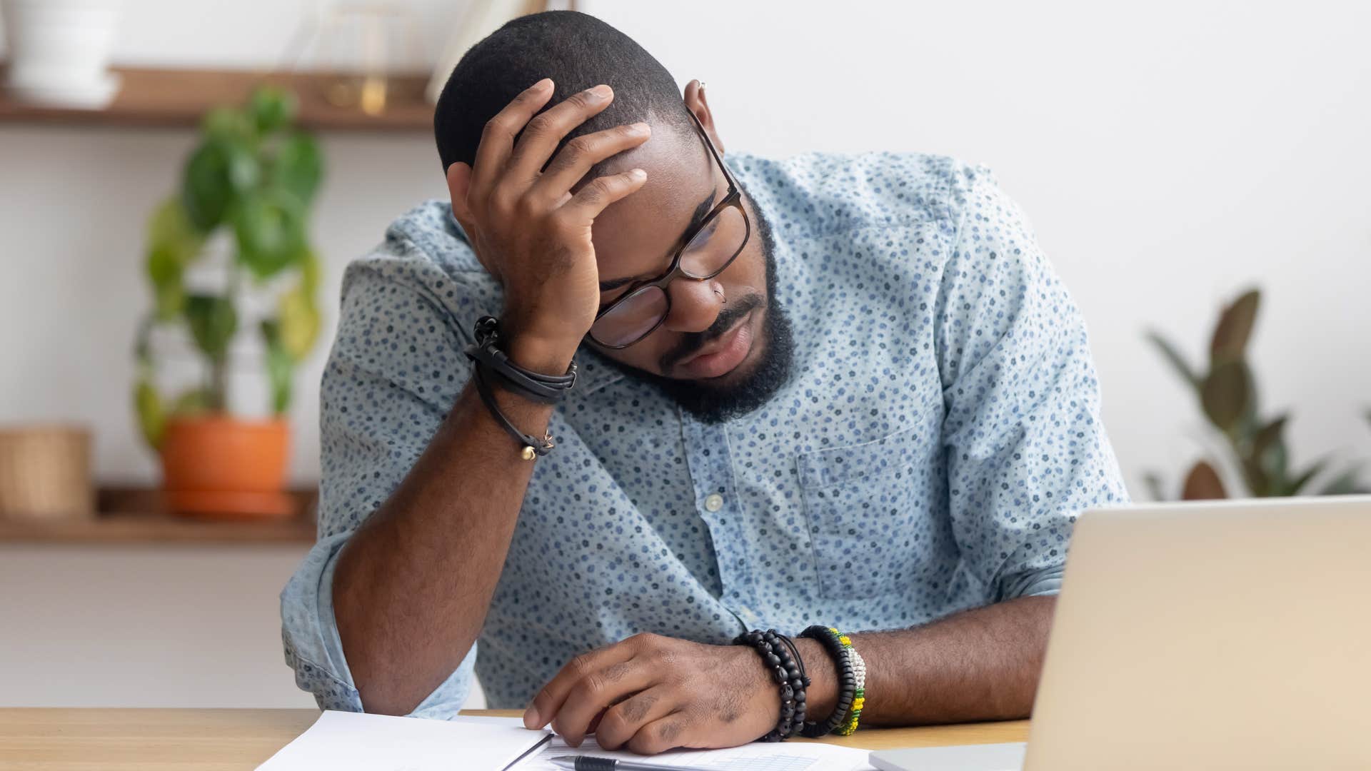 Man holding his head and thinking about goals without purpose.