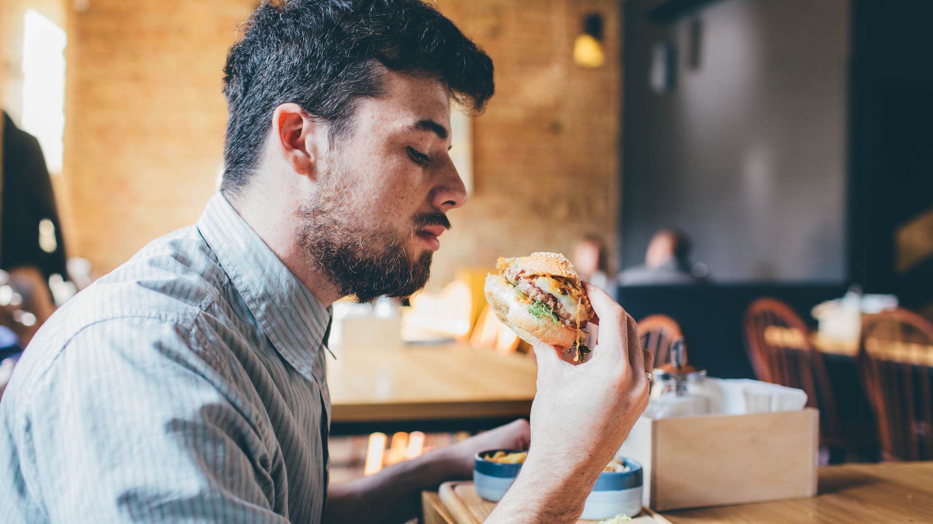 Man eating junk food at a restaurant.