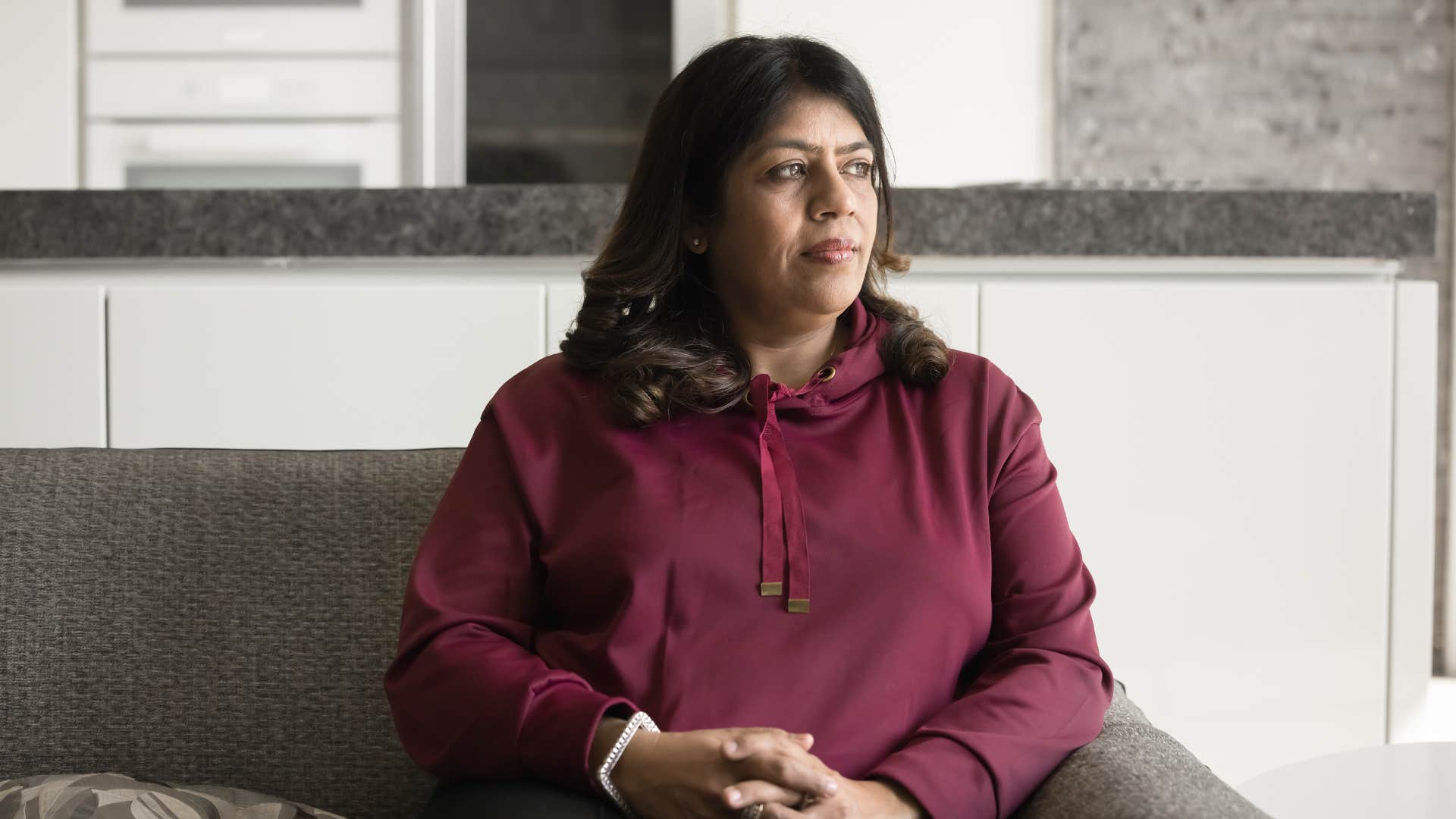 serious woman sitting on couch thinking