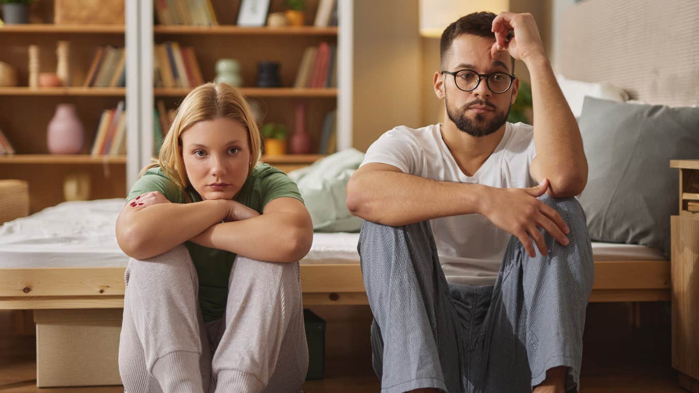 unhappy couple sitting in front of bed together