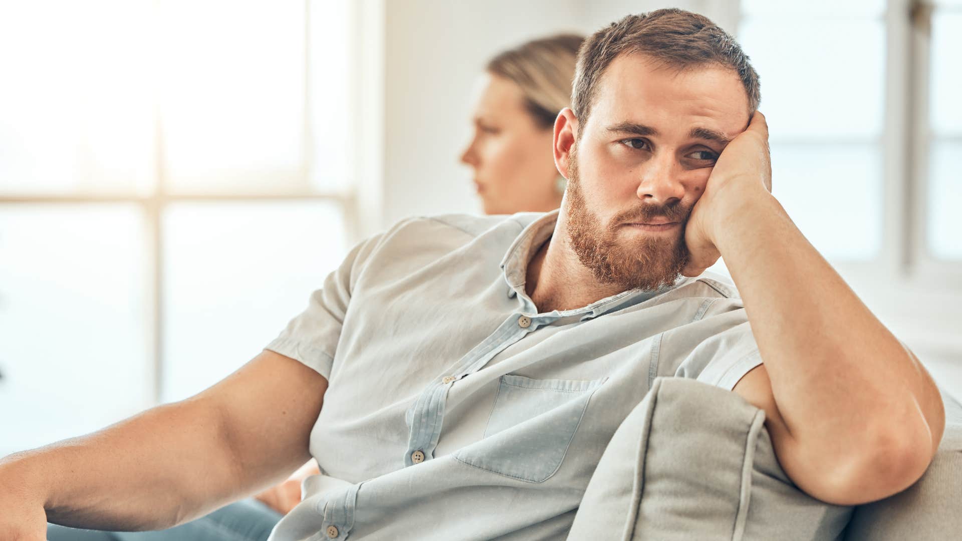 man turned away from wife looking at home decor