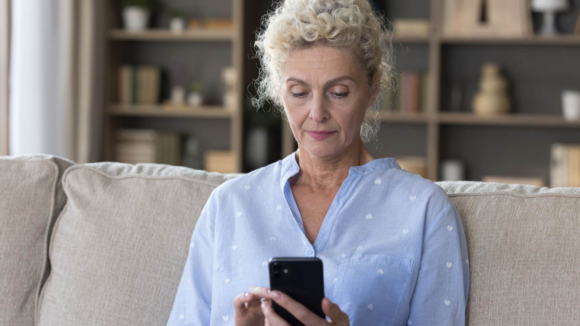 woman looking at different calendars on her phone at home