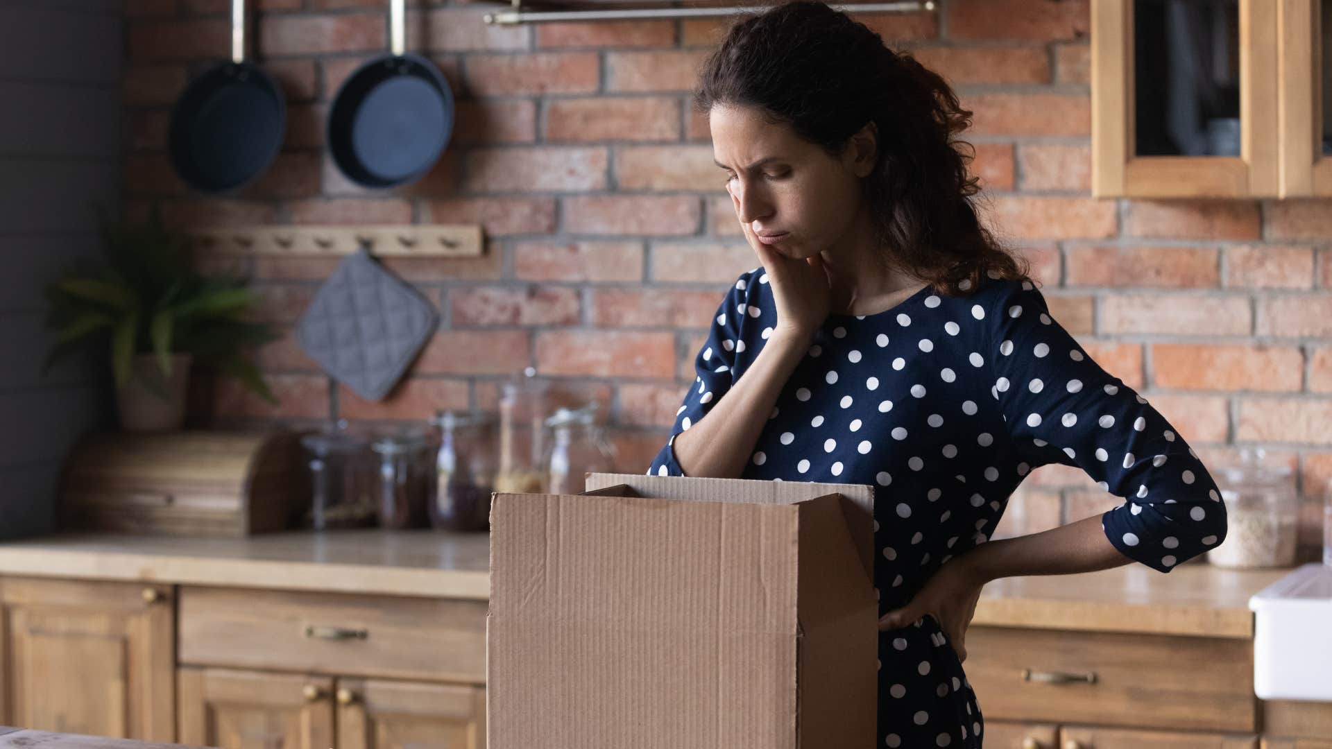 woman looking at unopened gifts in her kitchen