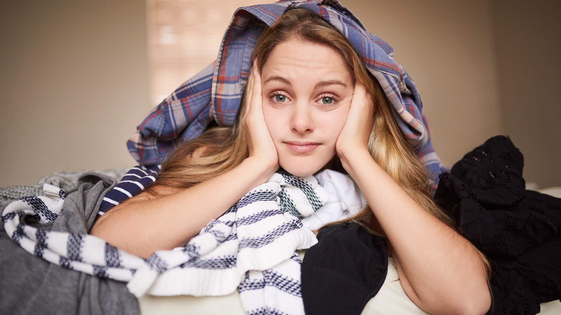 Woman with bad organization skills sitting with her laundry.