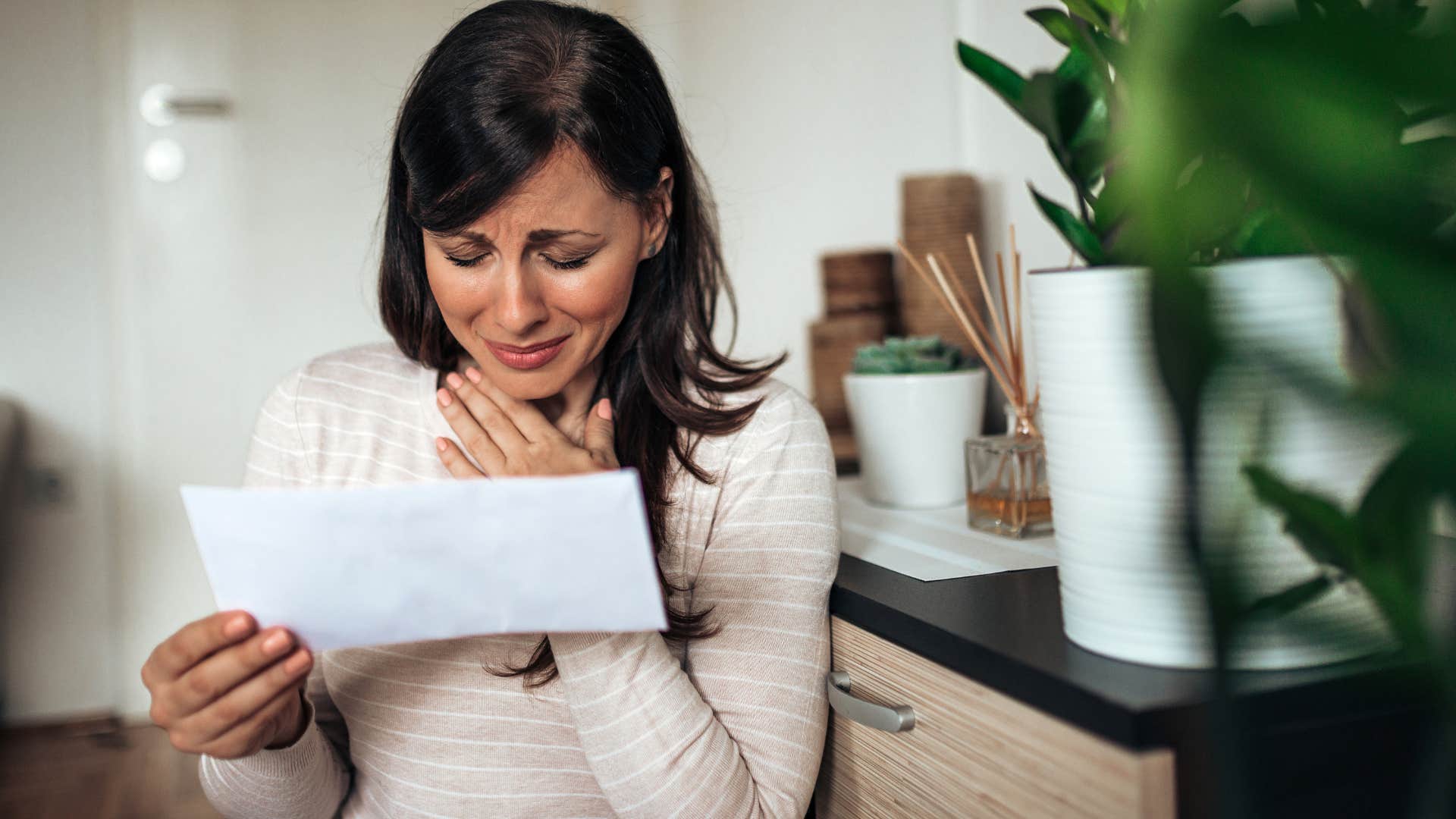 Woman looking at sentimental childhood items at home.