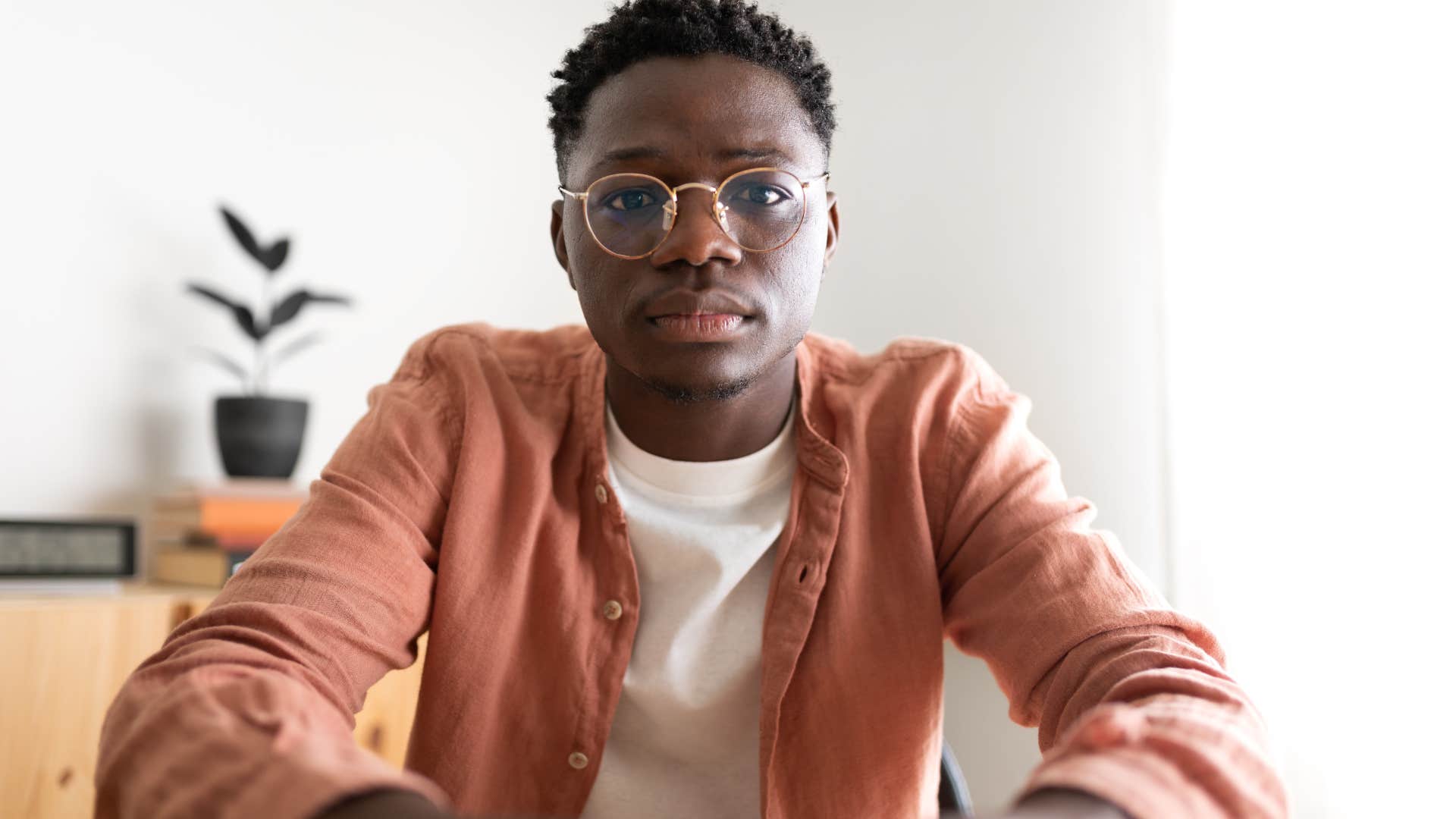 Man sitting at home with no artwork or personal photos.
