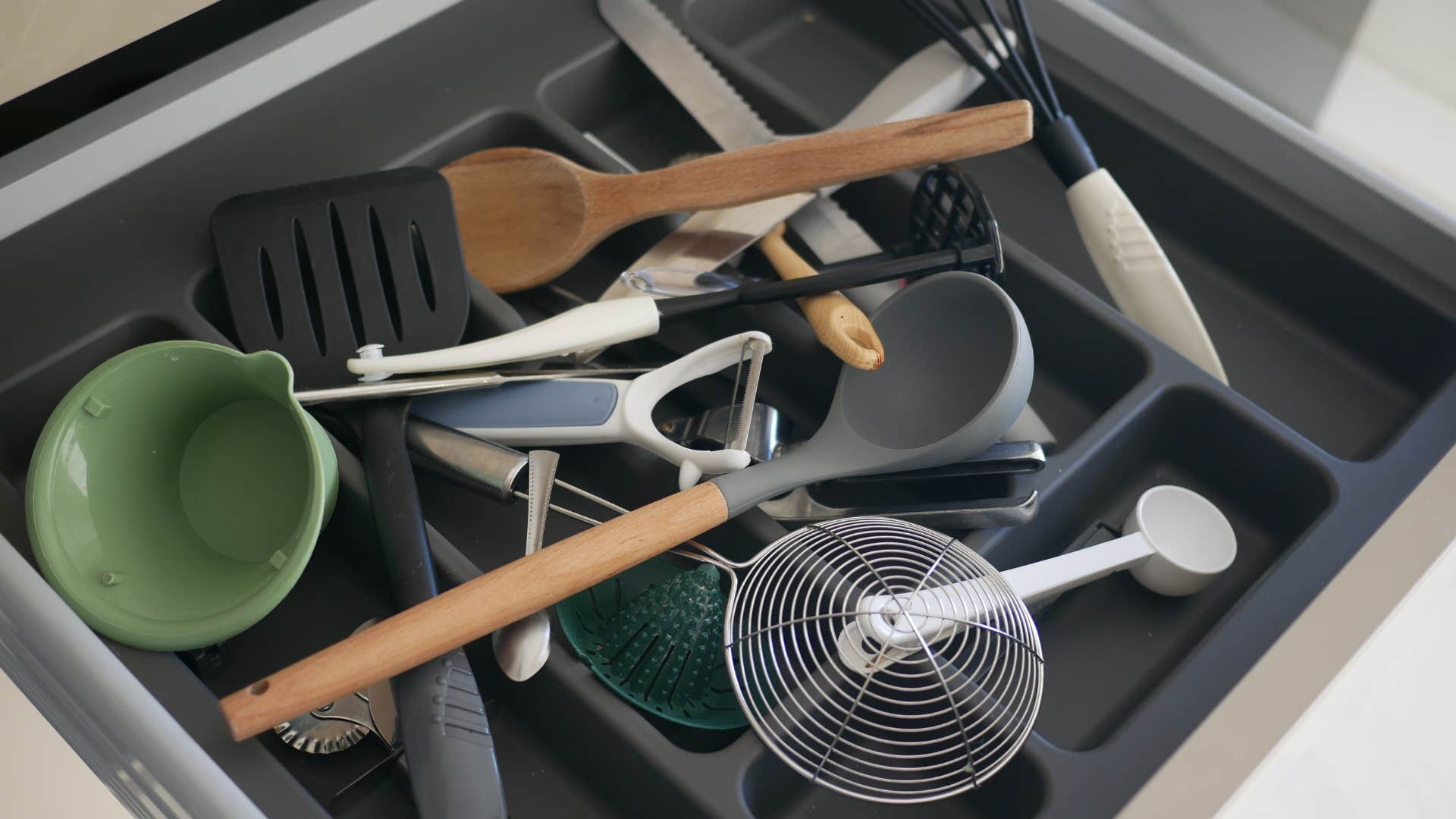 a homeowner has an unorganized drawer of kitchen tools