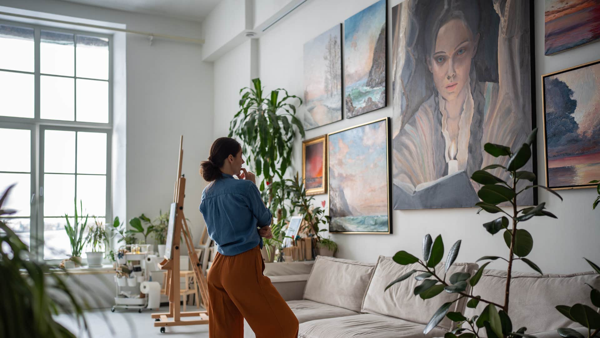 a woman debates whether or not to put her a frame on a work art like she did for the others