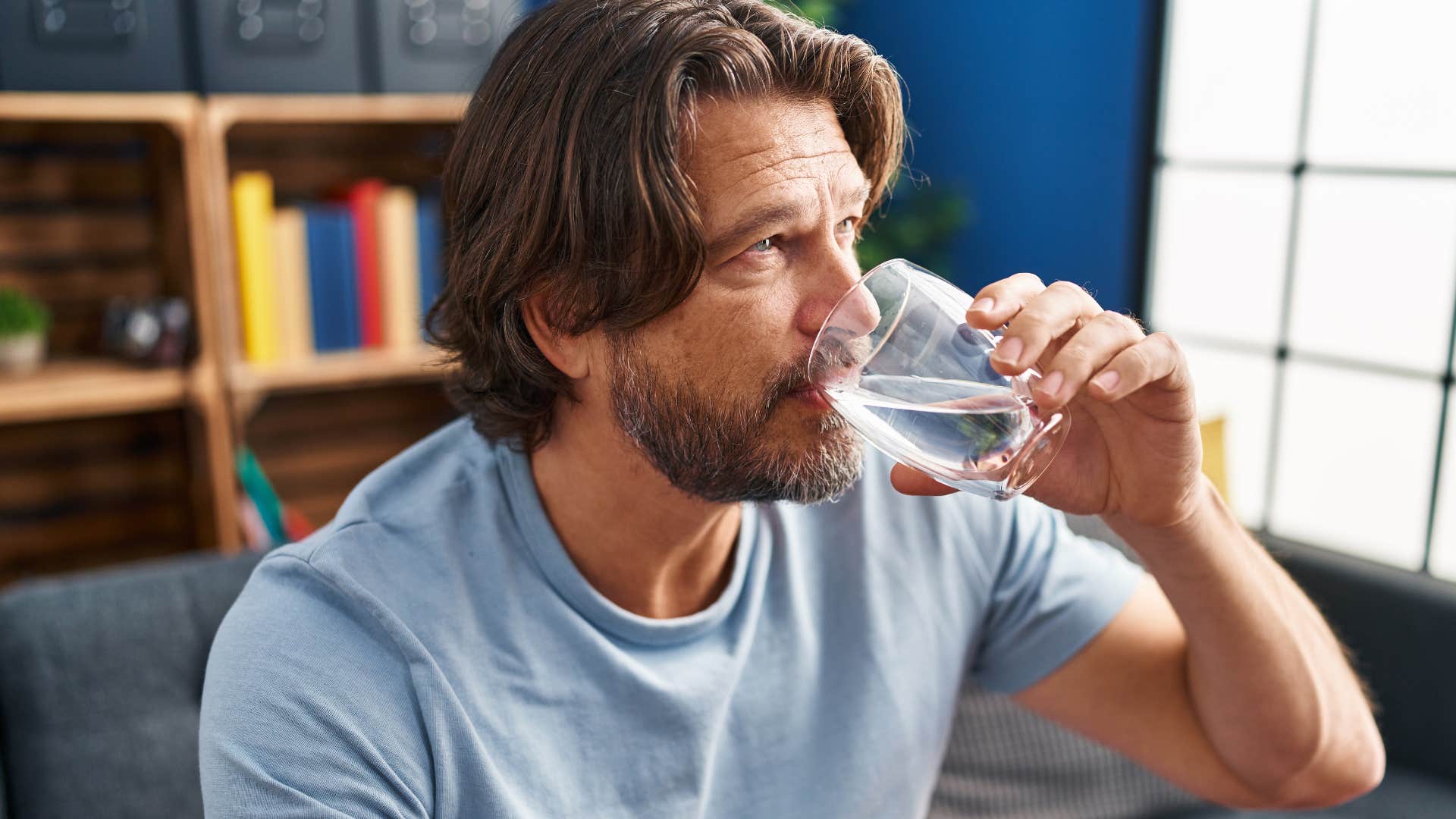 man drinking water from chipped glassware