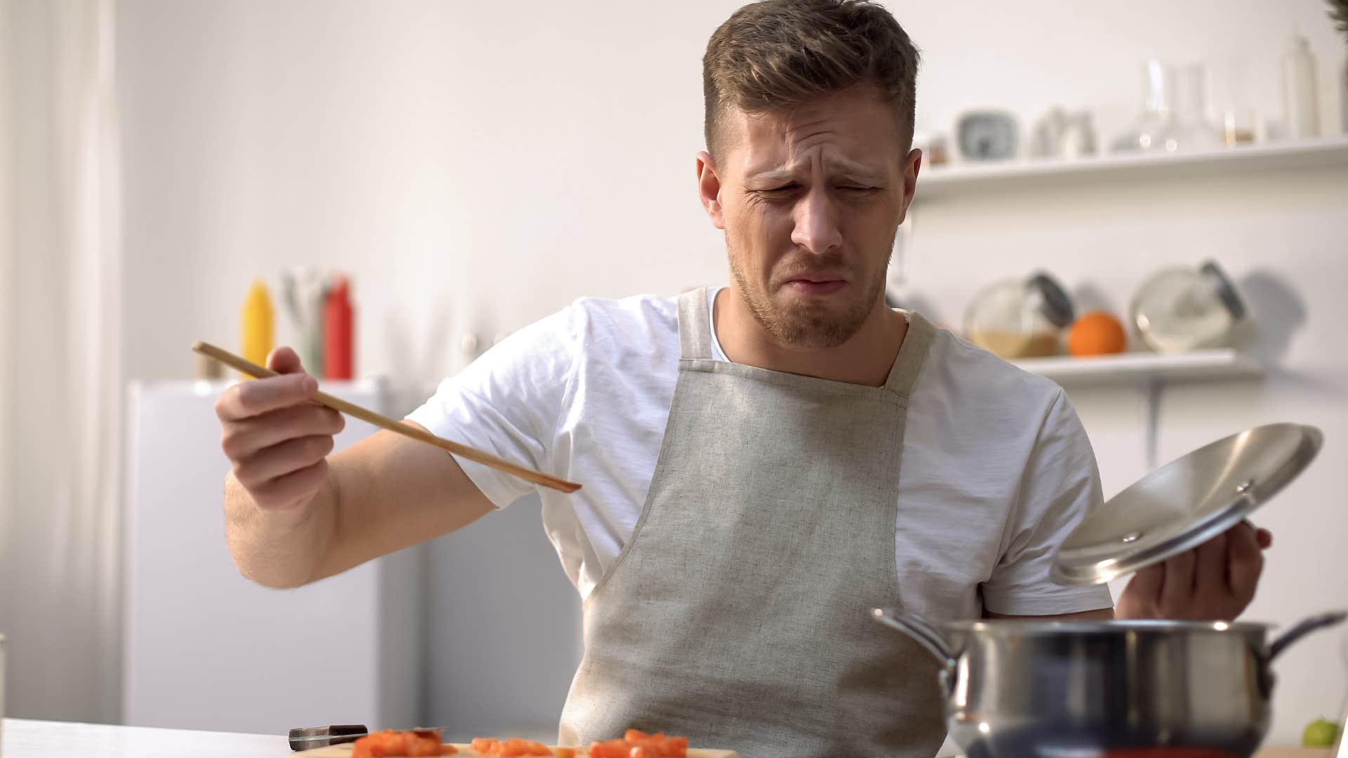 upset man cooking with overused pans at home