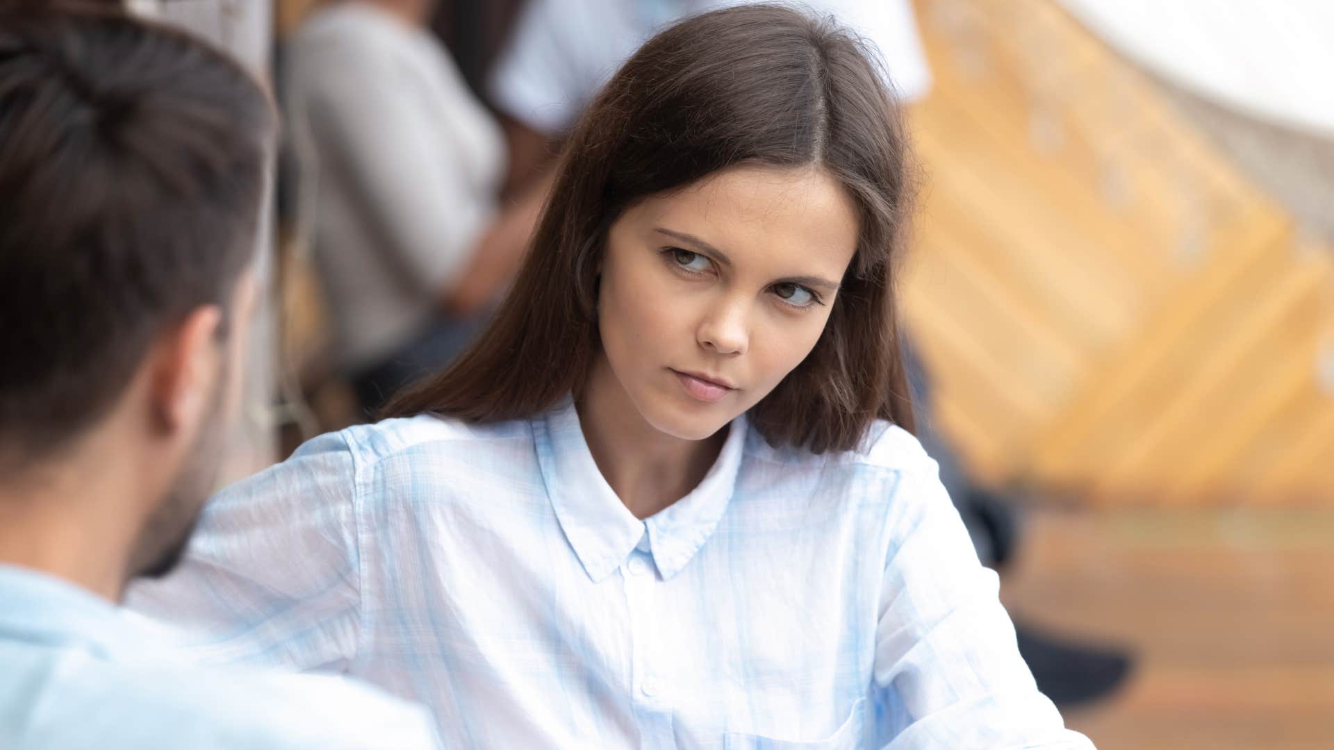 woman in white shirt saying why do you think that is to man in blue shirt while she stares at him confused