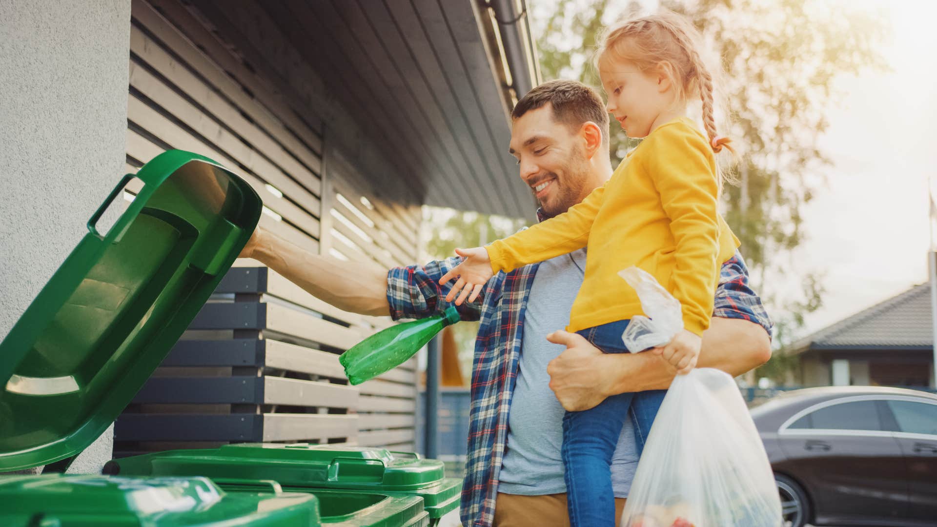 little girl throwing away leftovers with her father