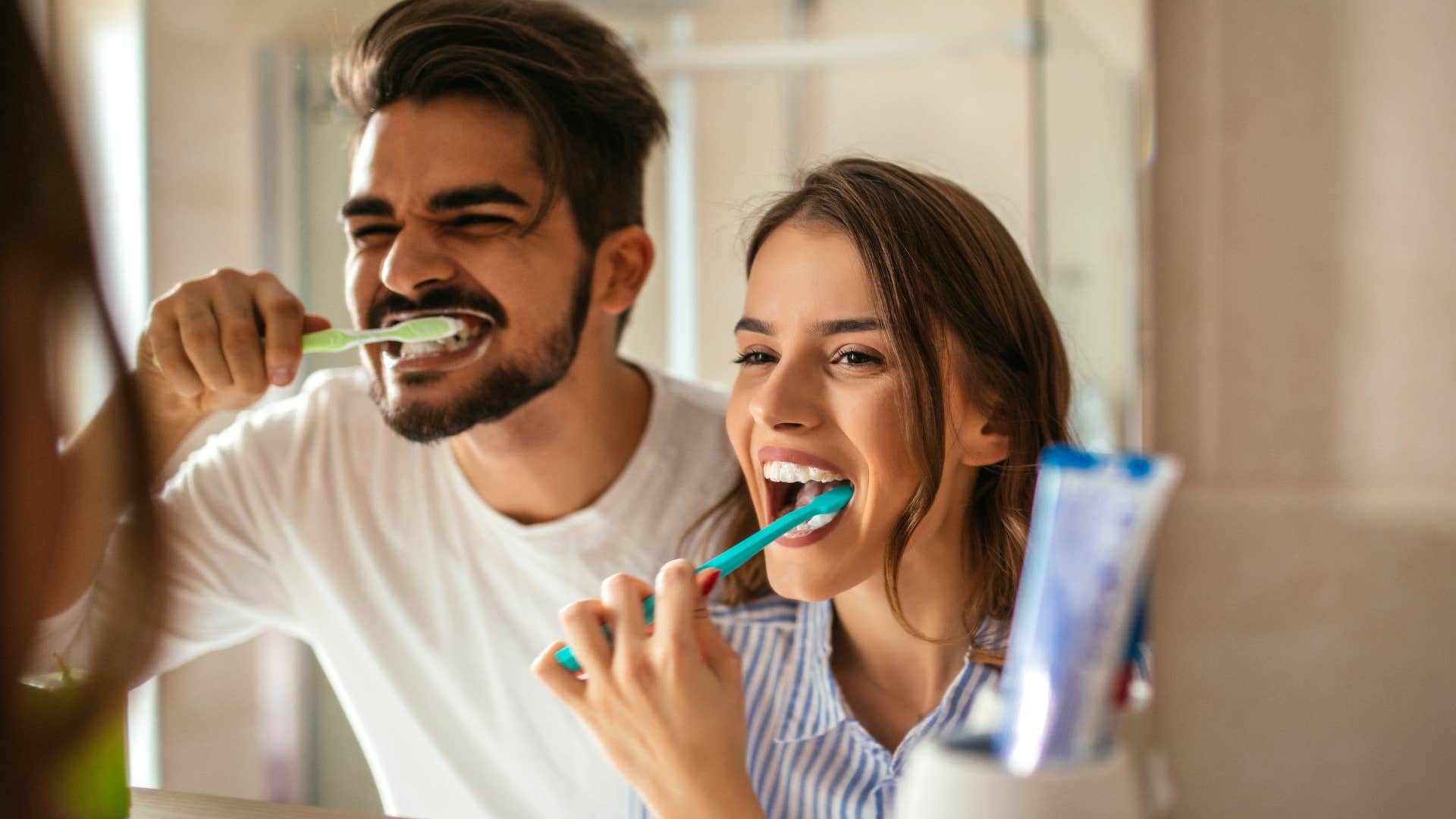 Couple brushing their teeth in a dual sink bathroom.