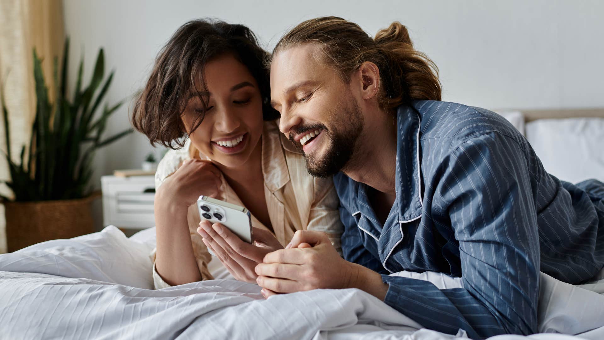 Couple smiling and relaxing in matching pajamas.