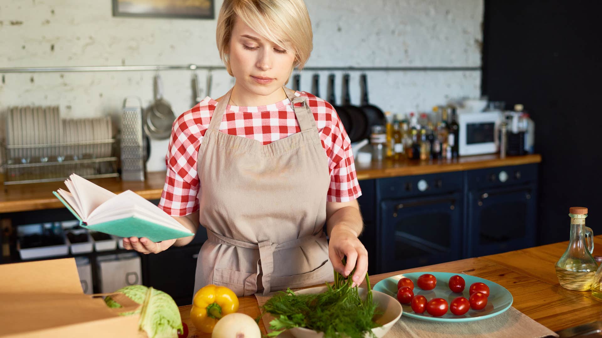 woman using cookbook in kitchen