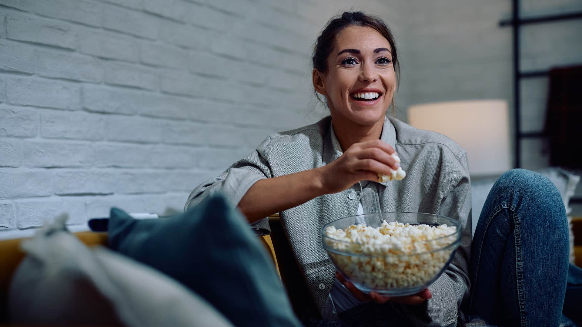 woman watching movie with popcorn at home
