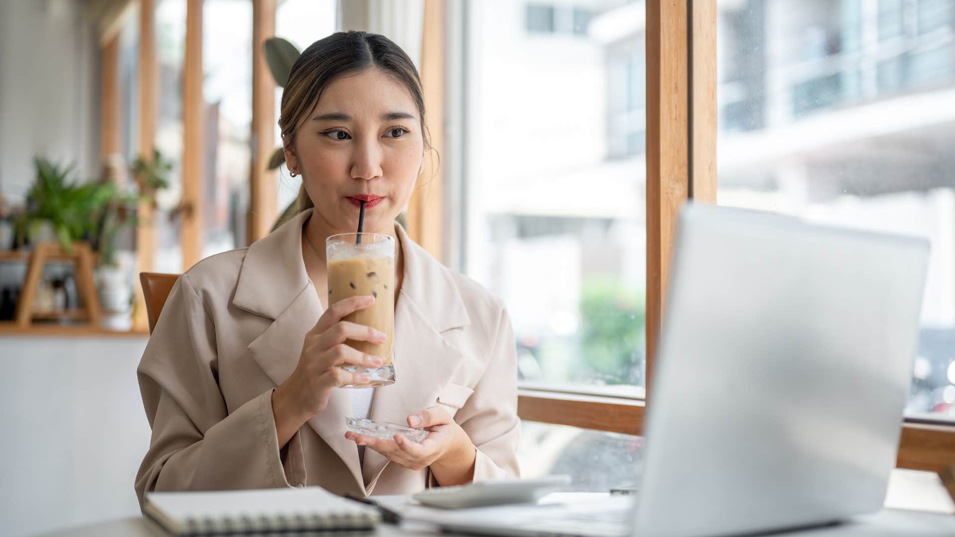 woman drinking coffee while holding coaster