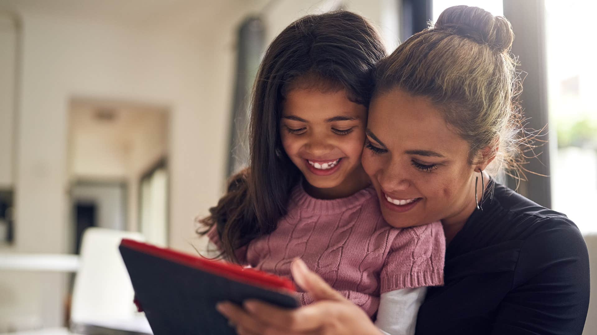 a gen x woman uses her daughters tablet with her
