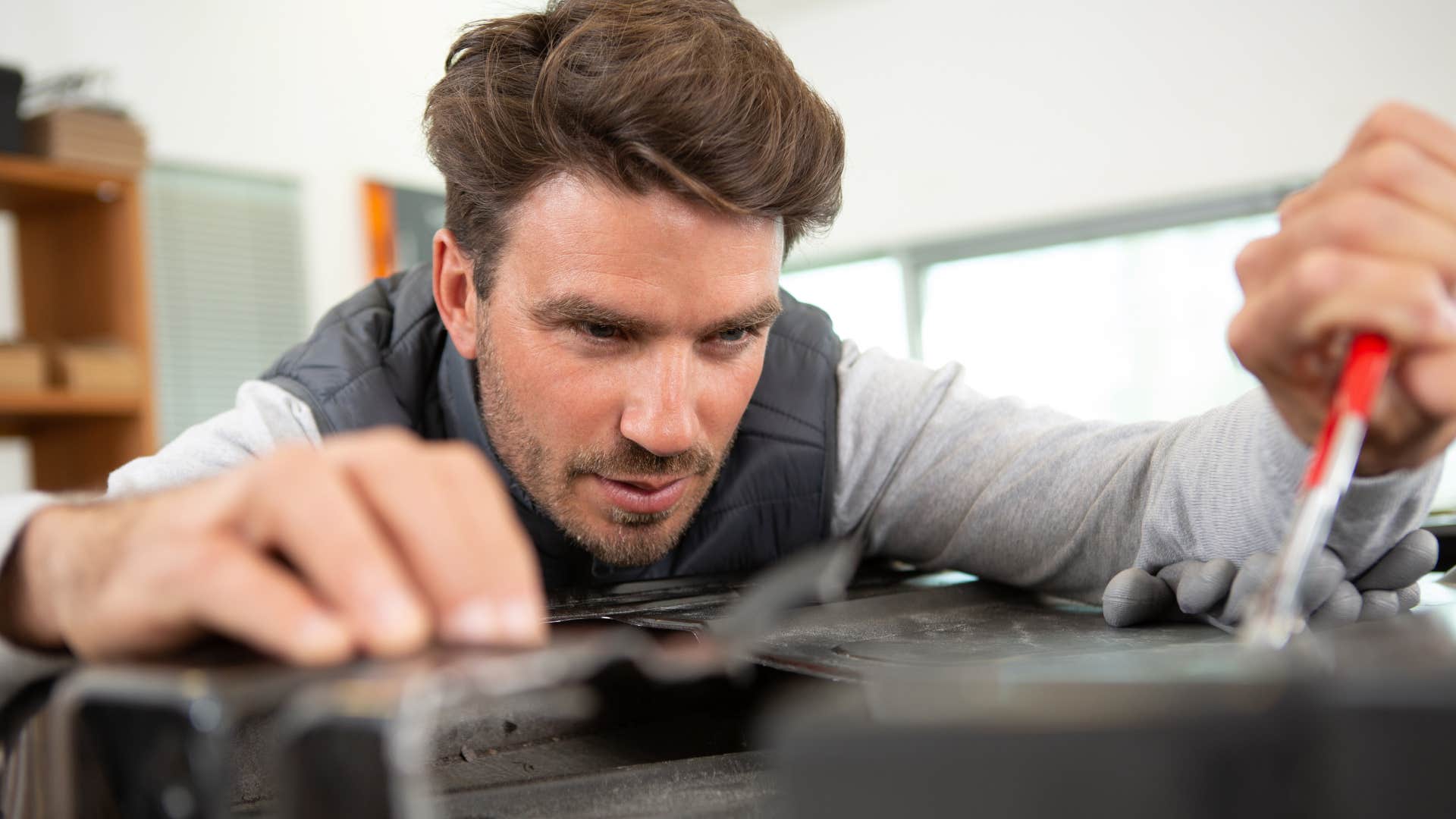 man using tool kit to fix something