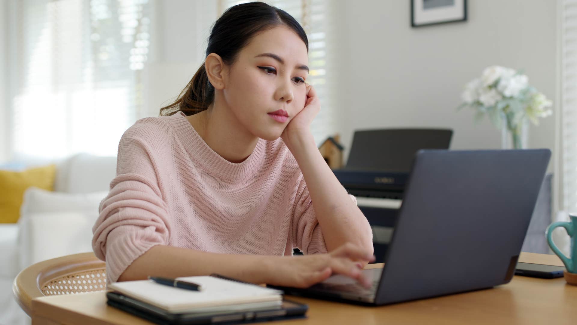Annoyed woman doing work on her computer thinking about inefficiency.