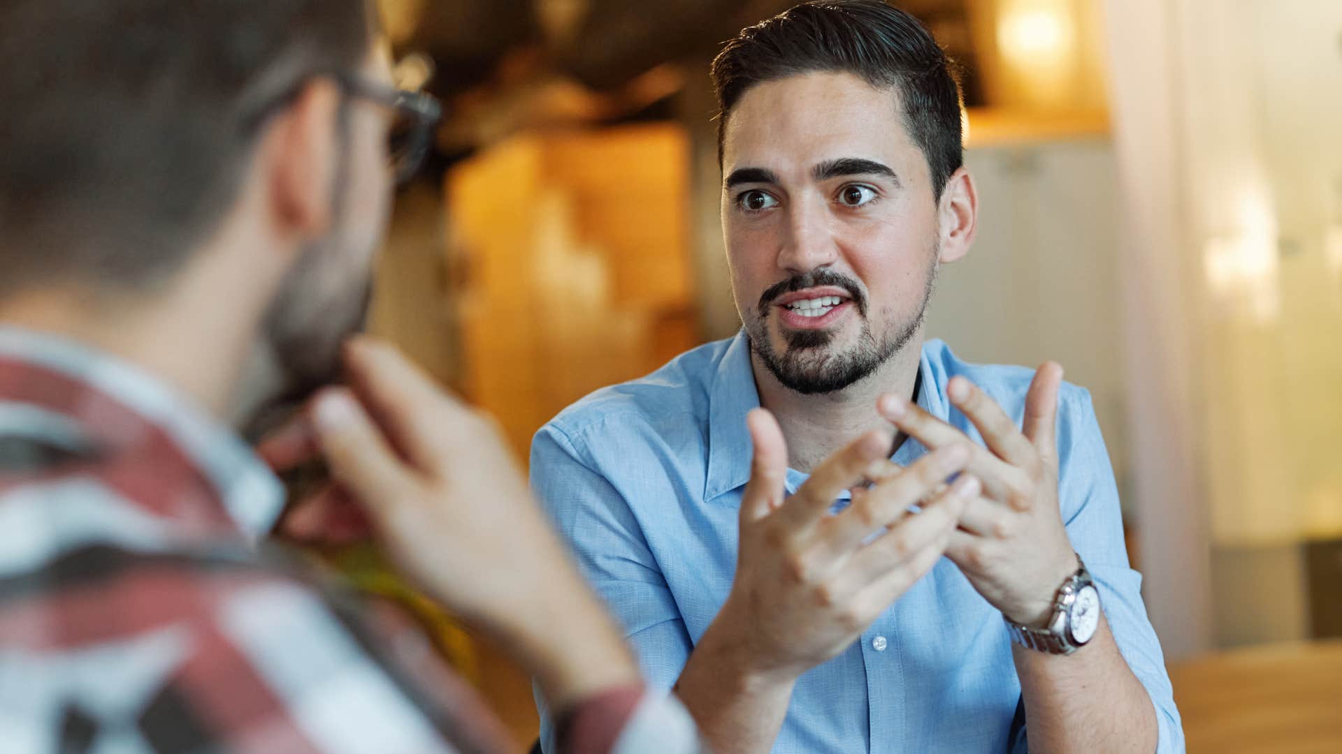 Man with overconfidence talking to a co-worker.