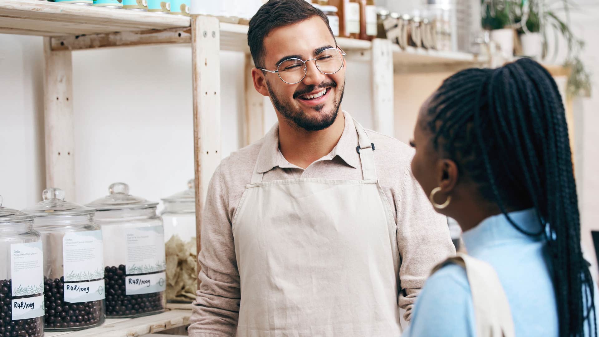 Man making small talk with a woman in a store.