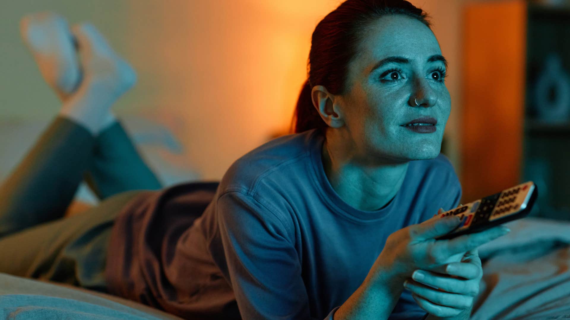 Woman watching a show on her bedroom TV