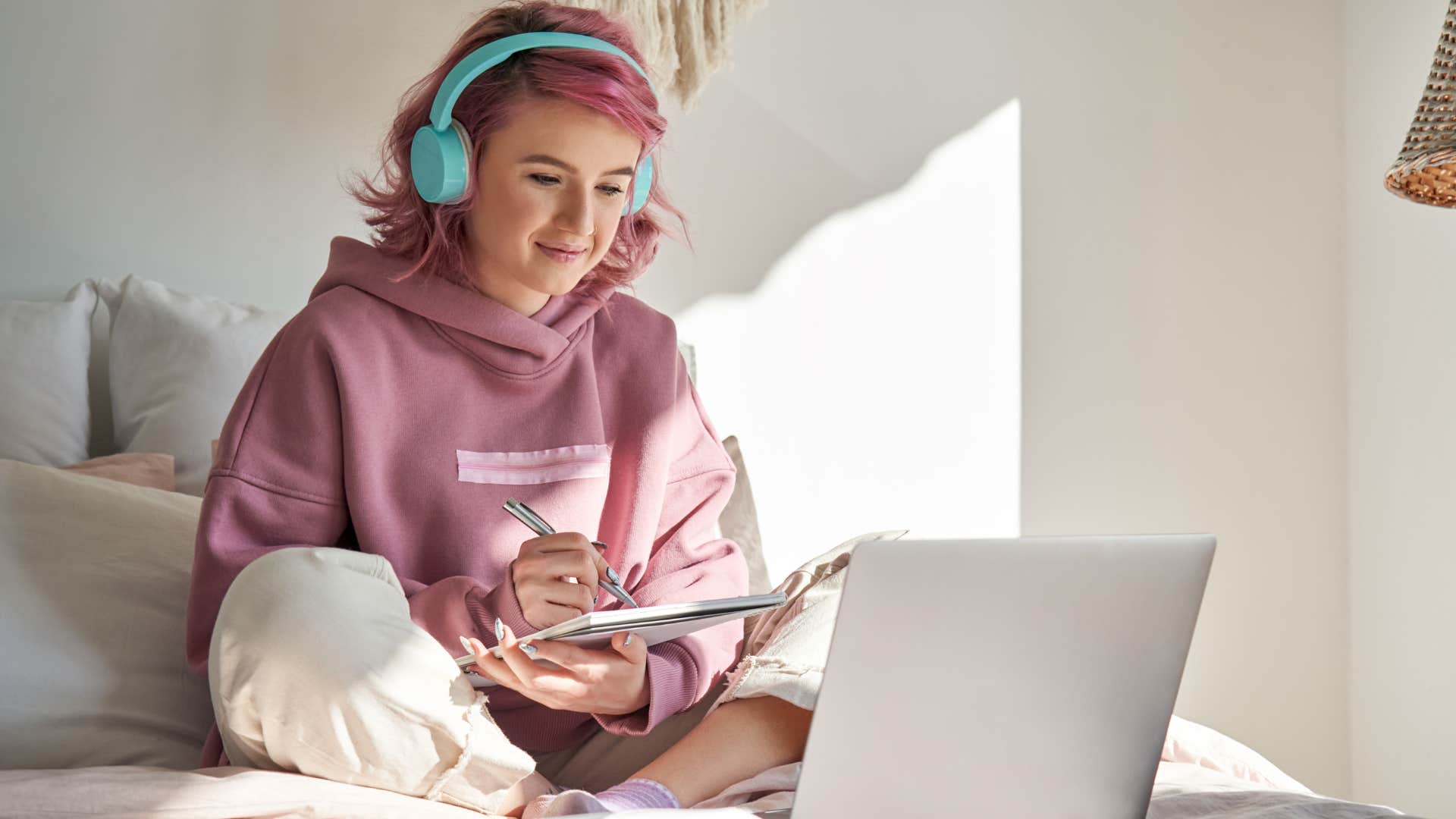 Teenage girl doing homework and smiling about having her own bedroom.