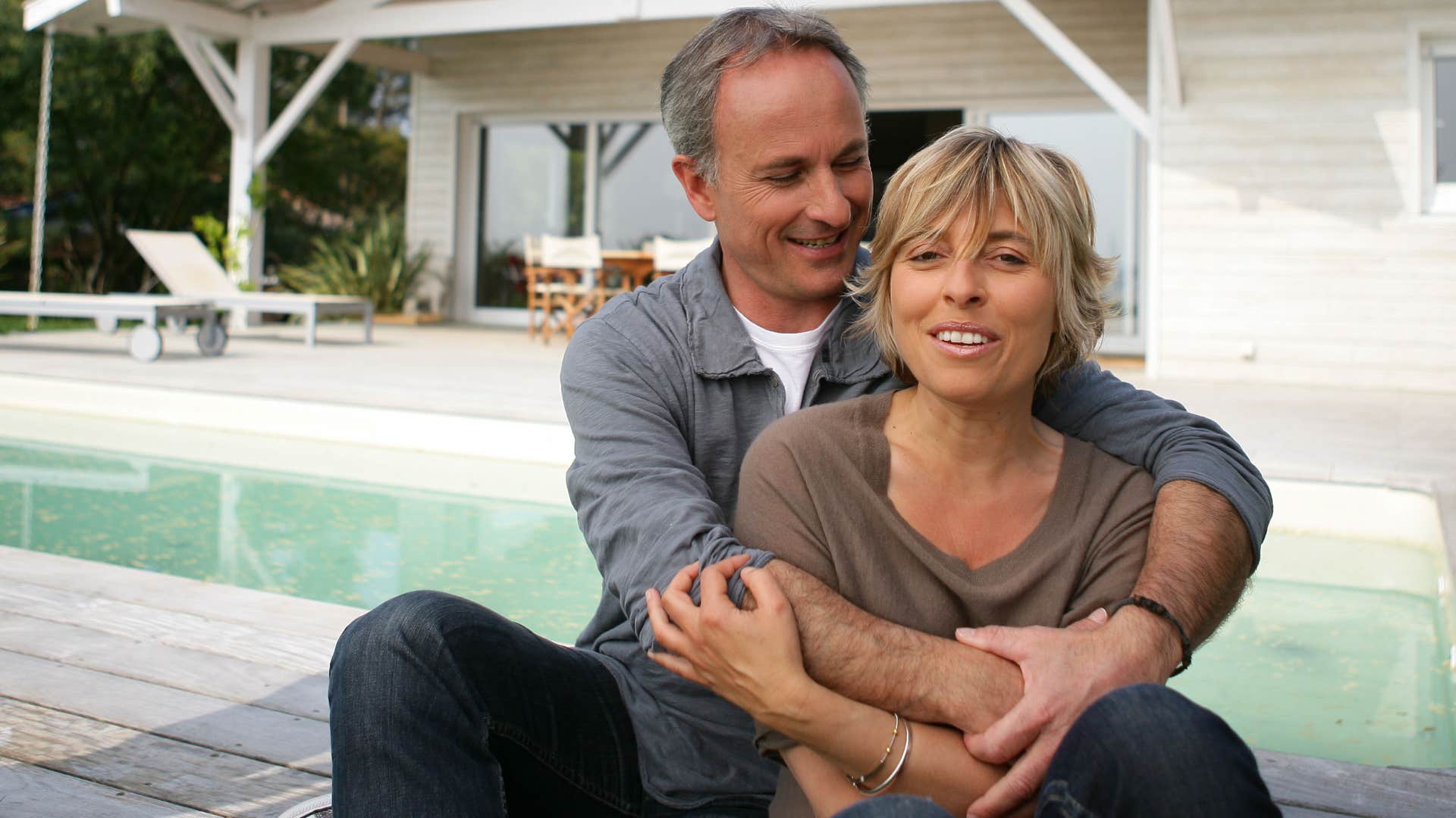 Couple smiling about having a pool at home.