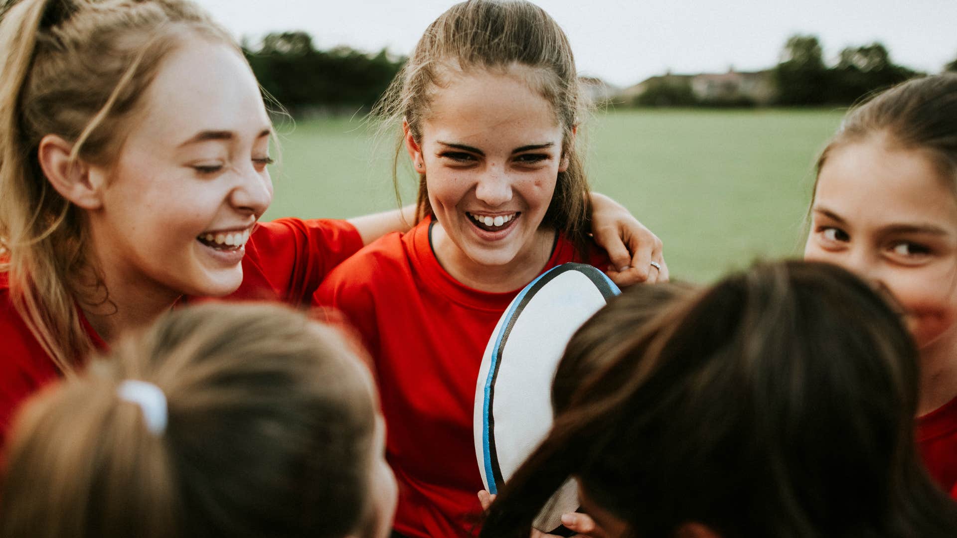 Little girls smiling about doing travel sports outside.
