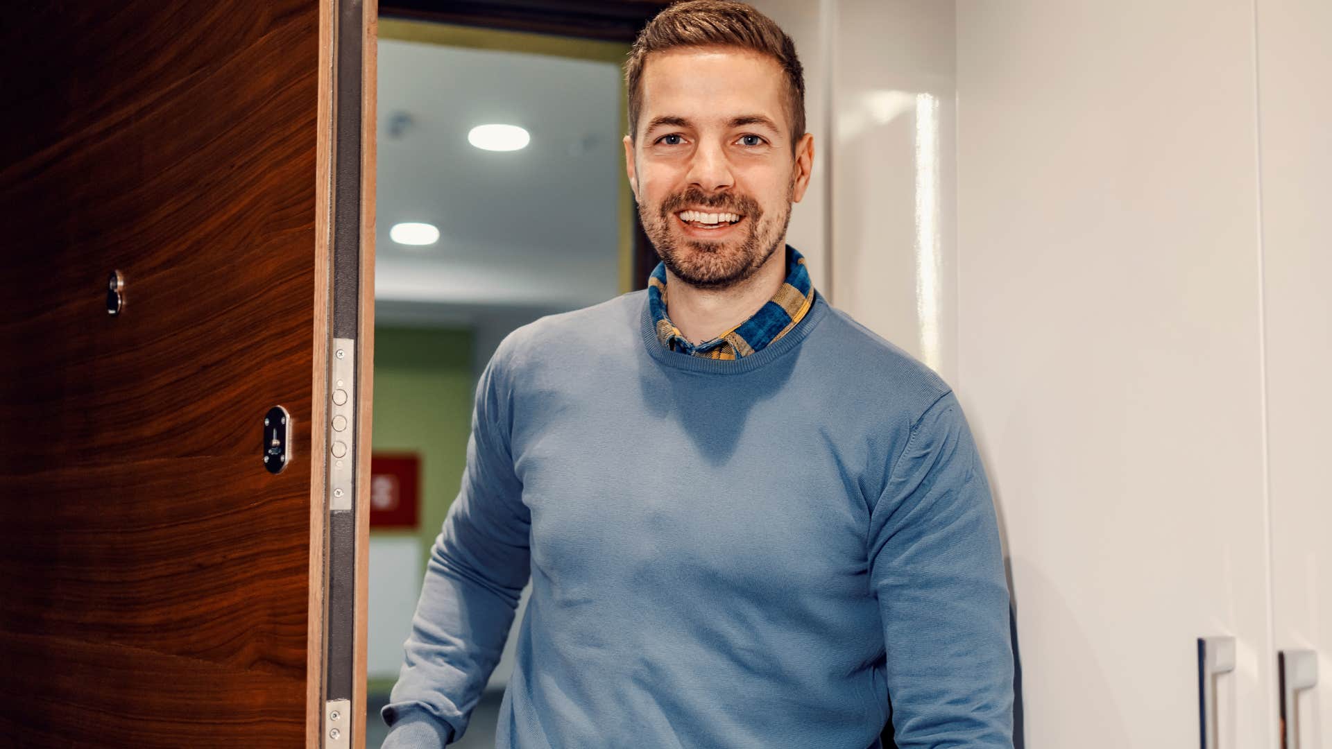 man blocking an entryway and smiling