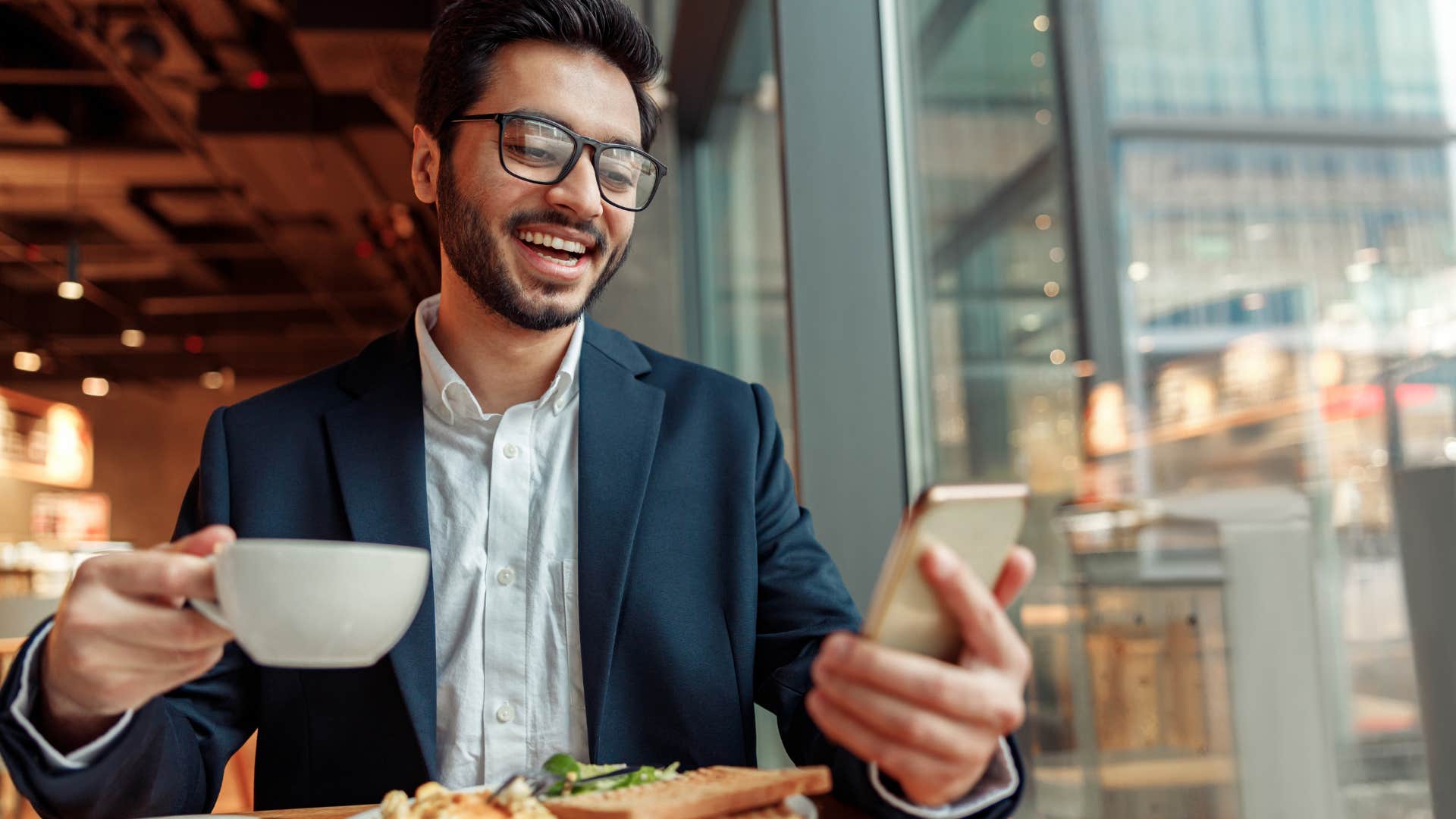 man smiling and eating at a restaurant