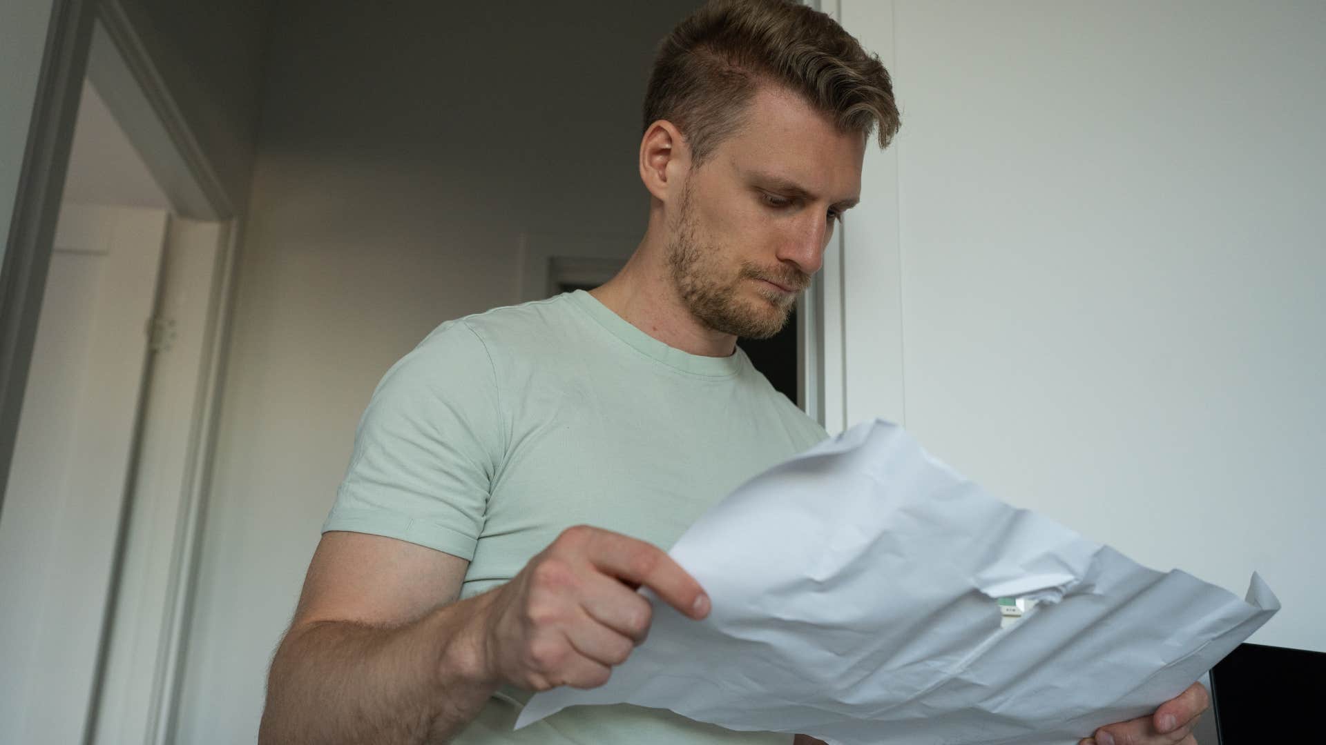 Man reading an appliance manual in his home.